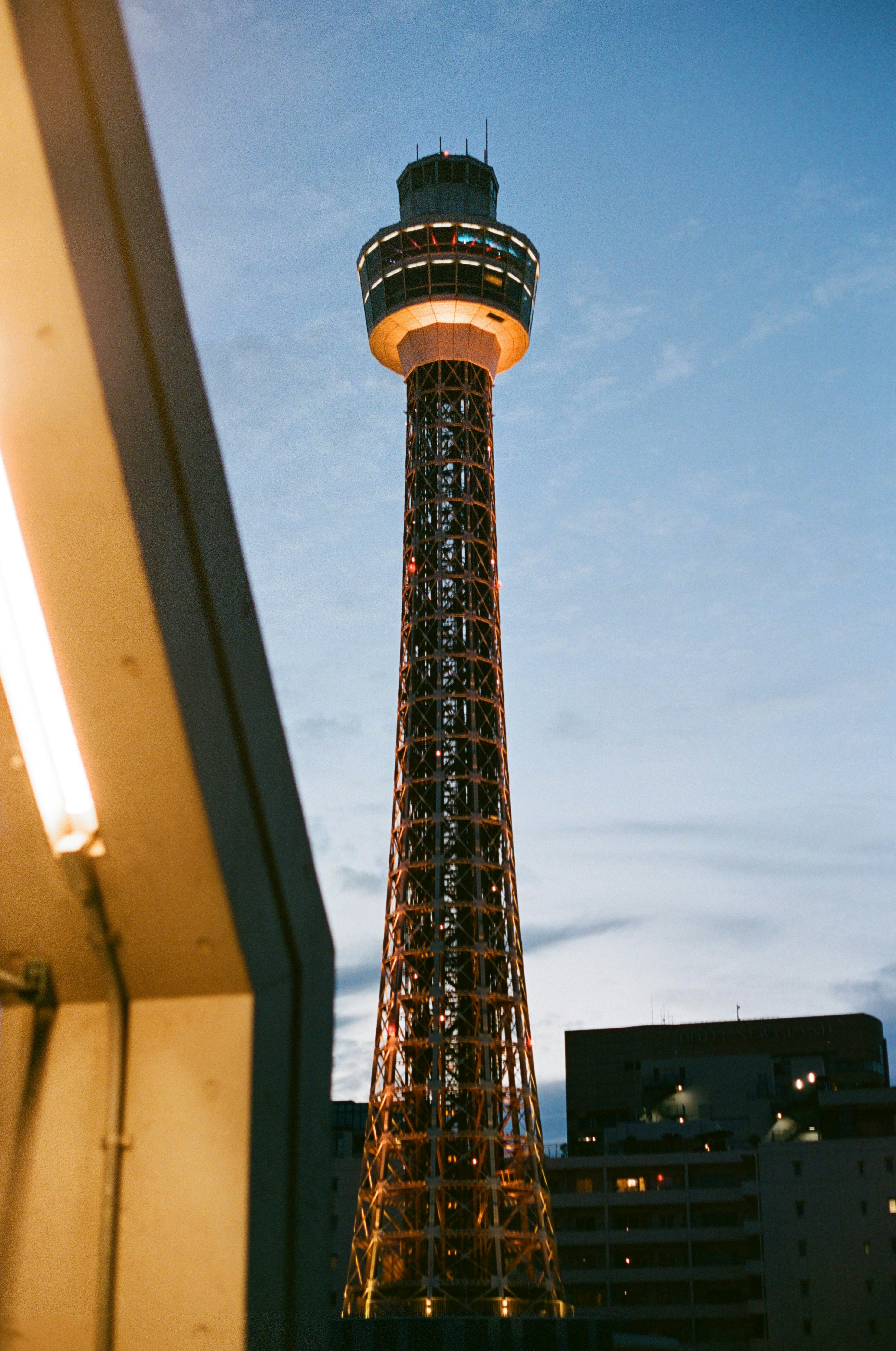 The Marine Tower illuminated against a blue evening sky in Yokohama