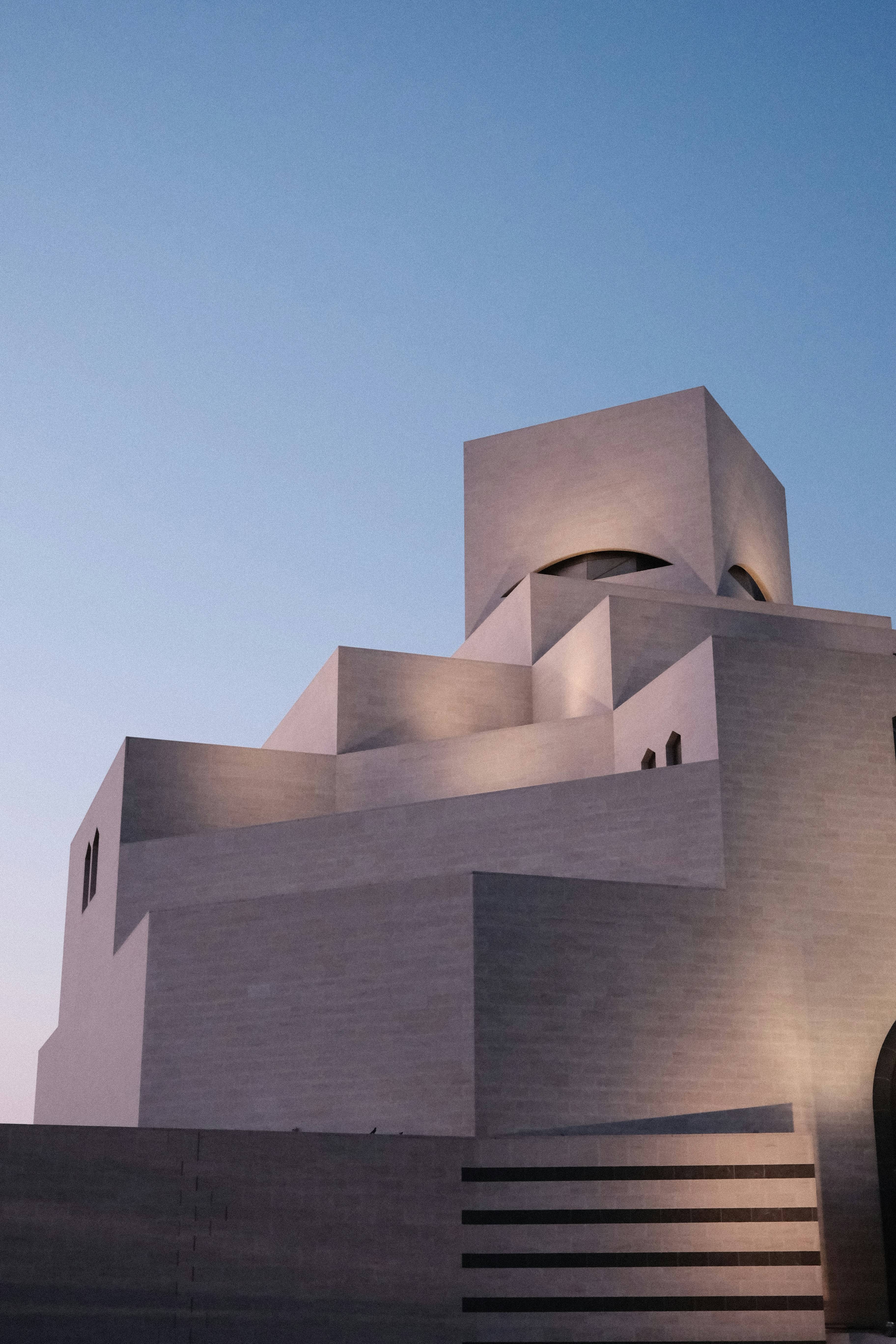 The Museum of Islamic Art in Doha with geometric stone architecture at dusk