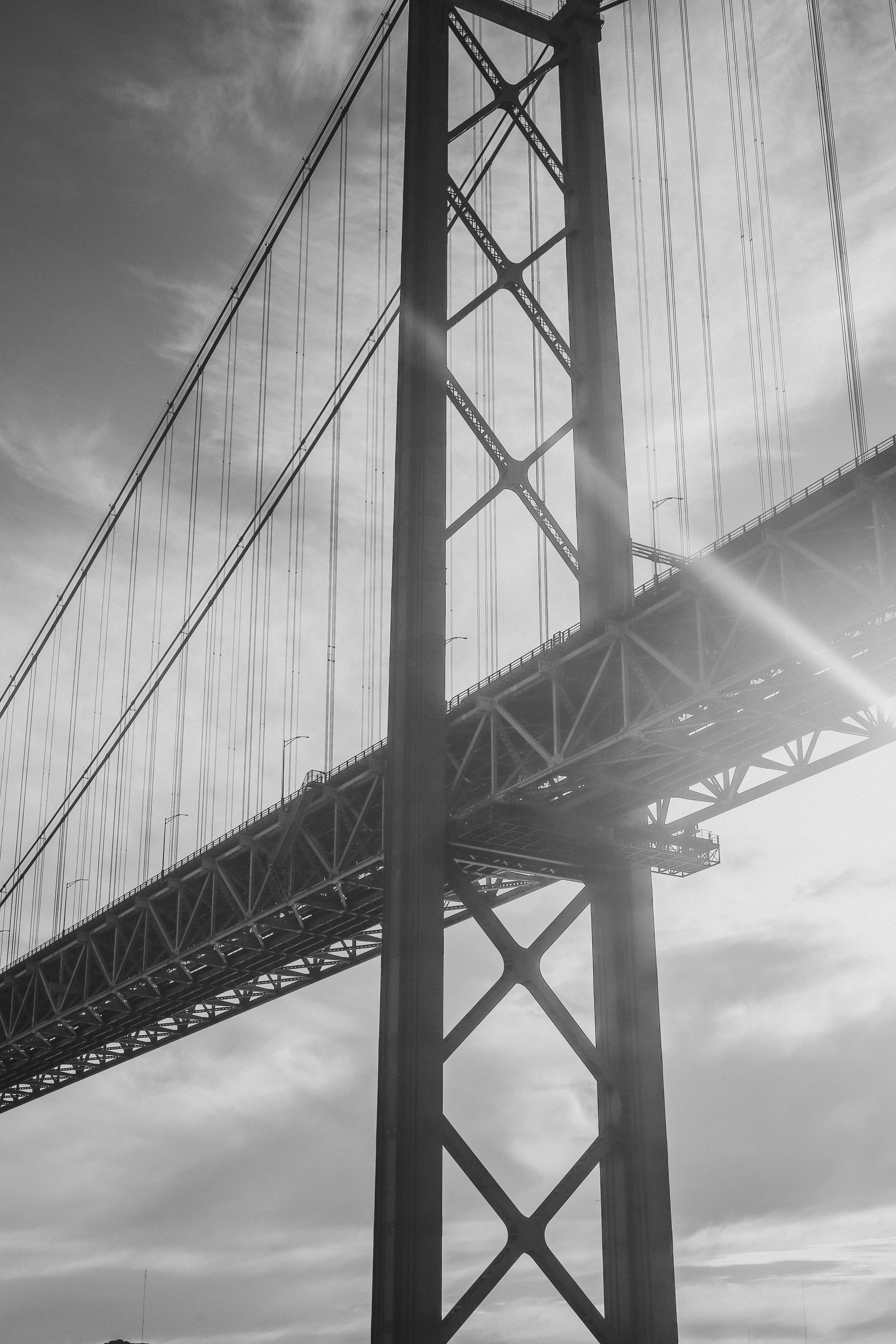 A black and white view of the 25 de Abril Bridge in Lisbon