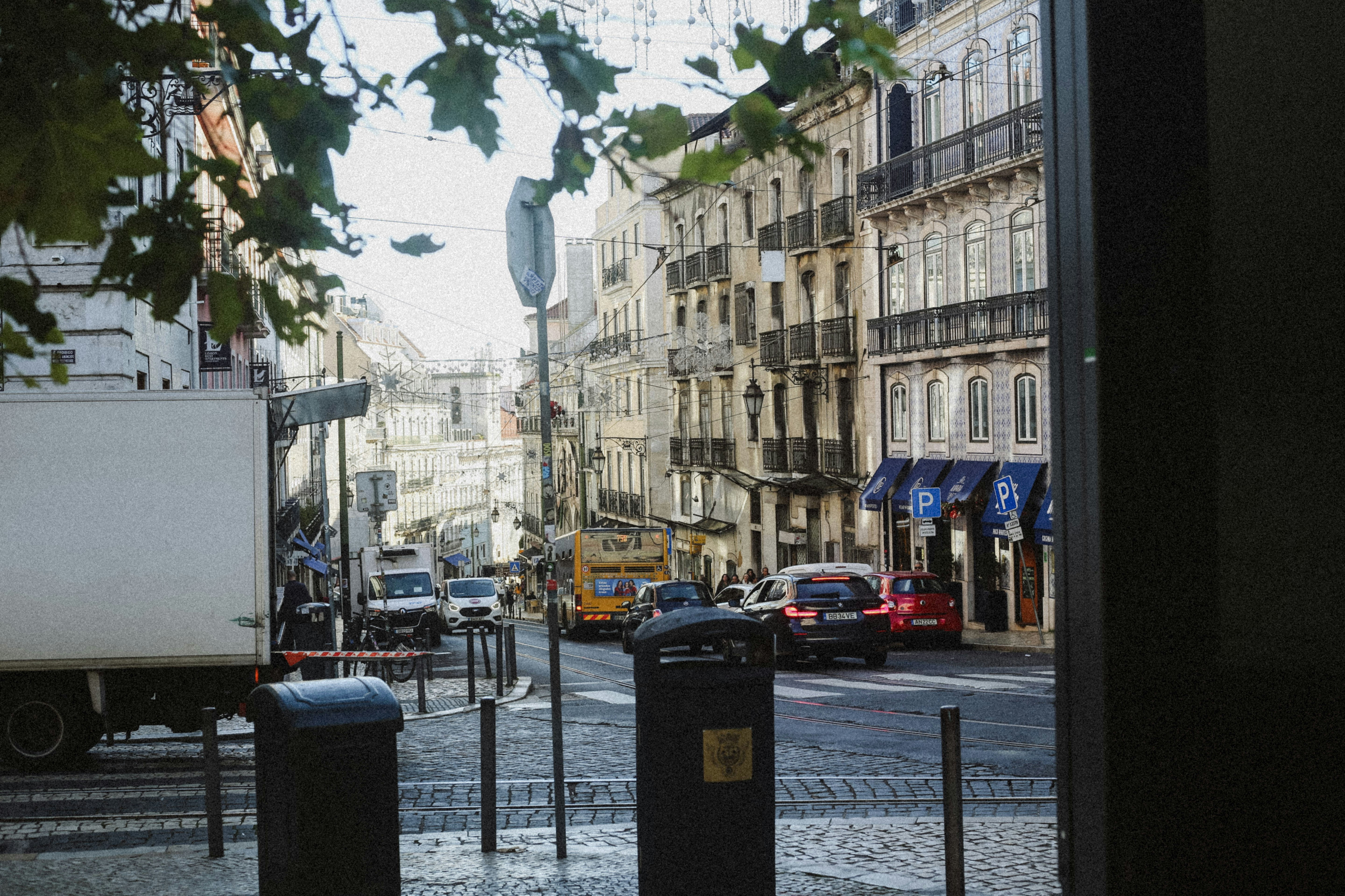 A busy street in Lisbon with cars, a bus, and historic tiled buildings
