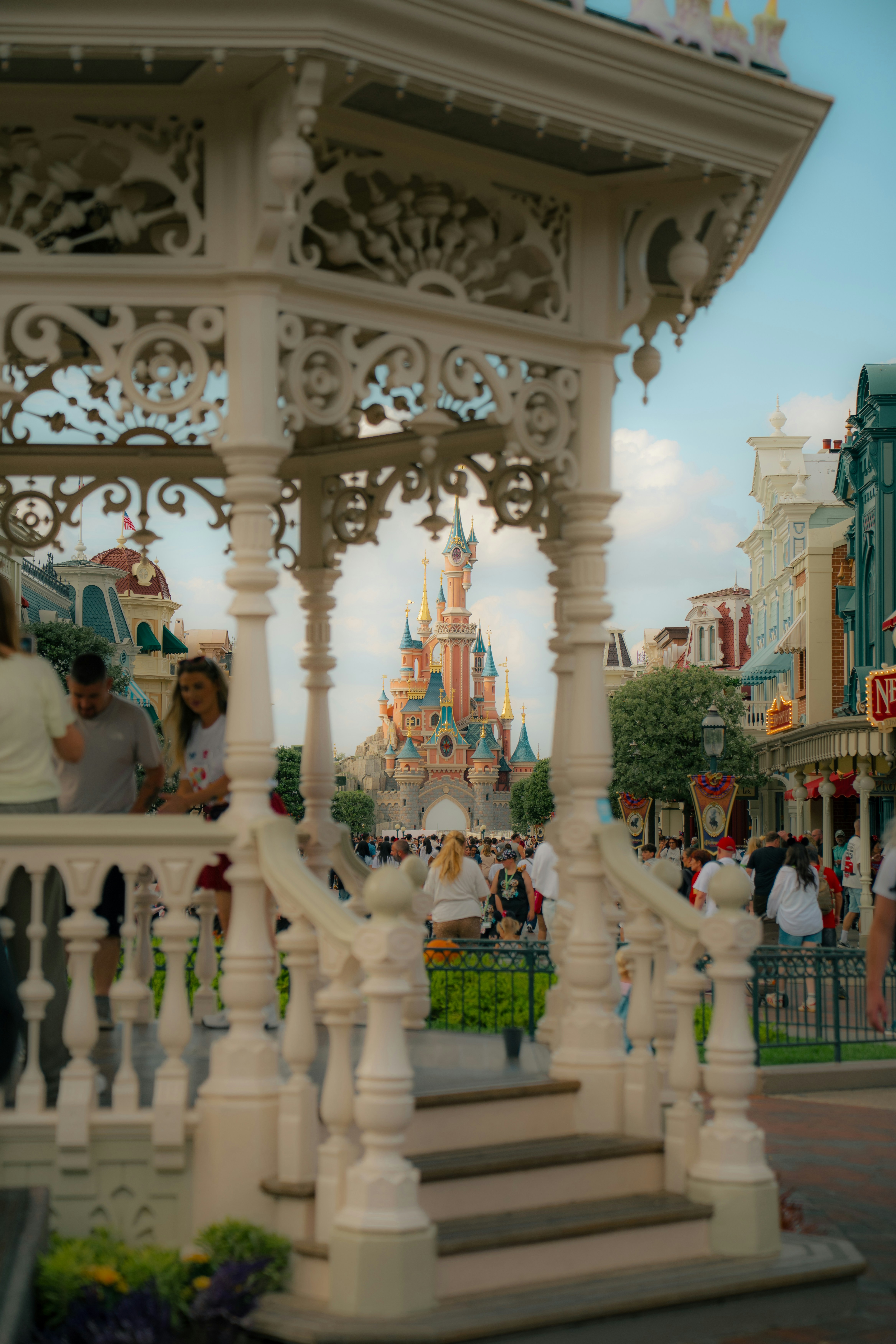 A view of Sleeping Beauty Castle framed by an ornate white gazebo in Paris