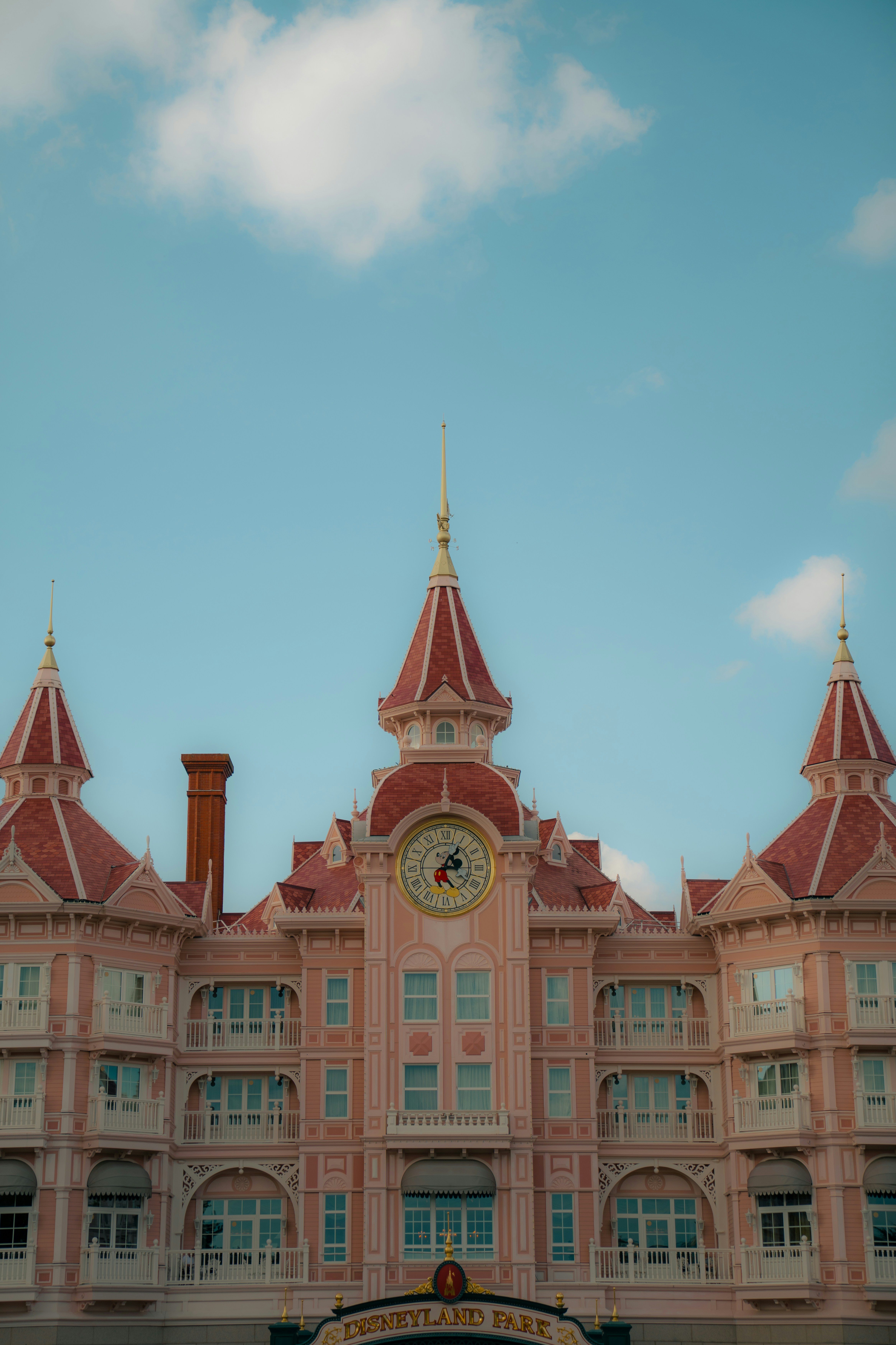 The Disneyland Hotel facade with a central clock tower under a blue sky