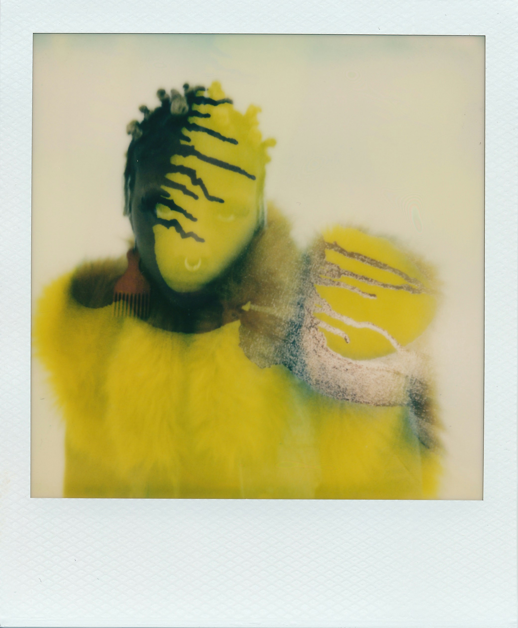 A person with dark hair and a yellow face in a fuzzy yellow garment