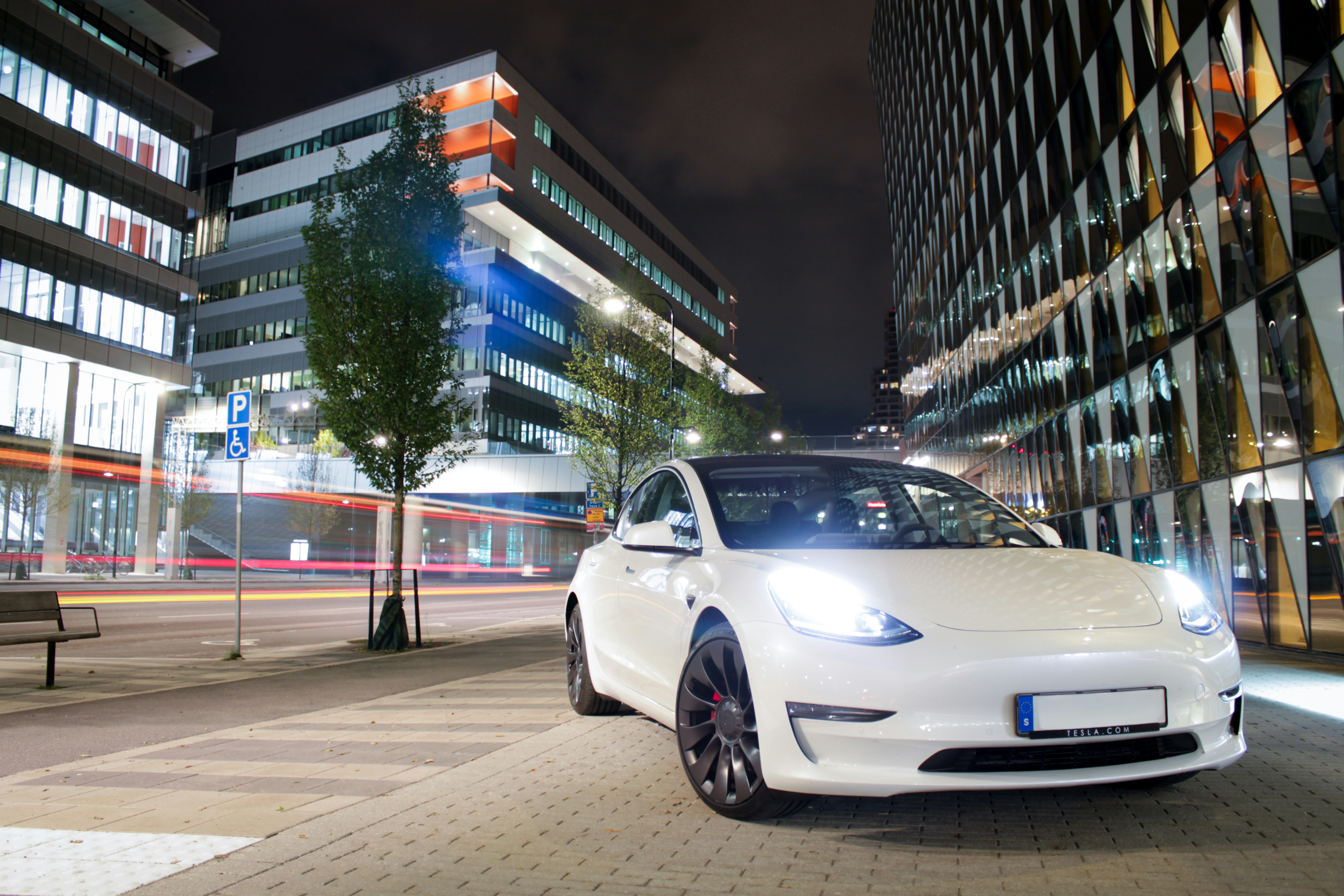 autonomous Tesla robotaxi vehicle driving urban street dusk