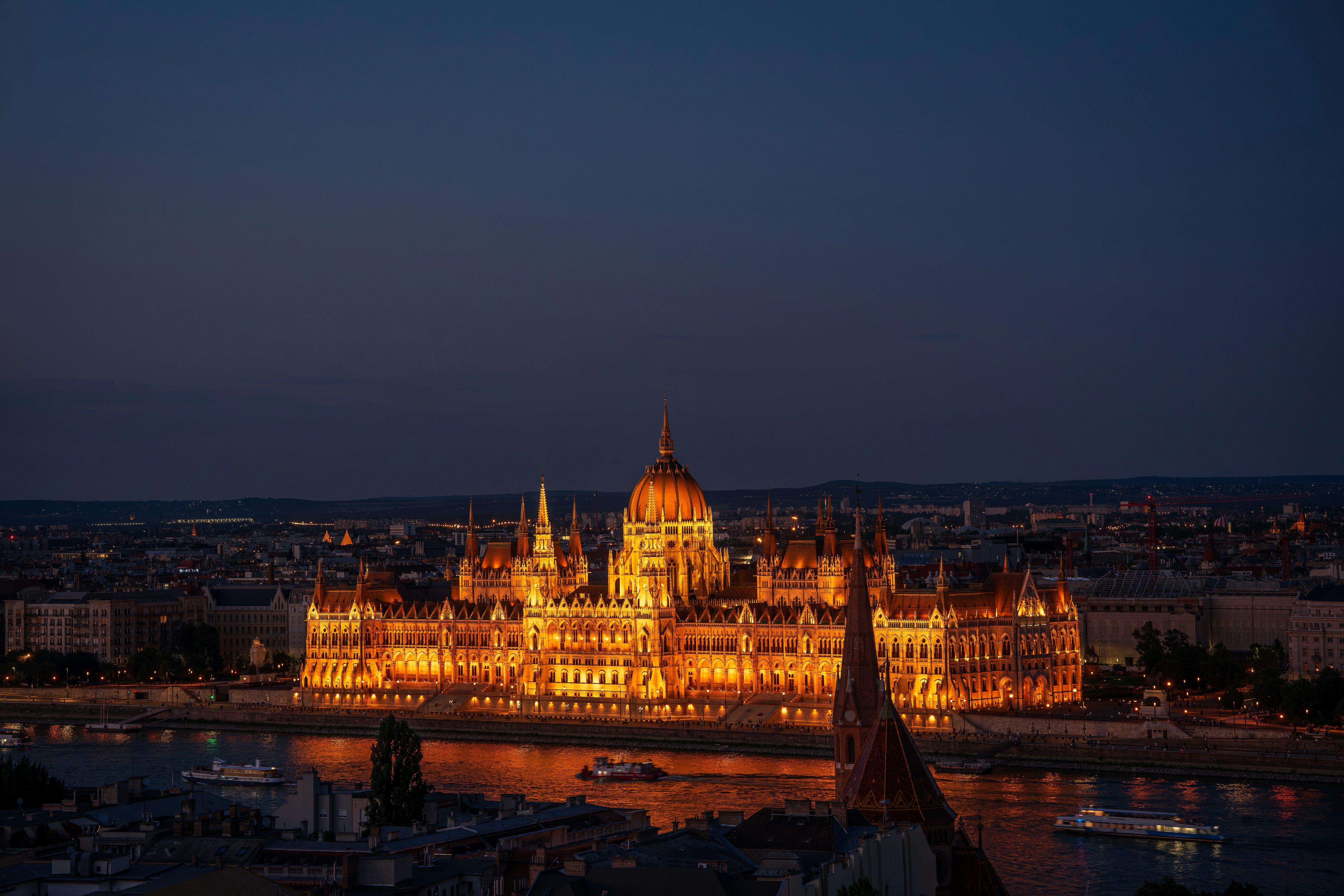 The Hungarian Parliament Building illuminated at night along the Danube River in Budapest