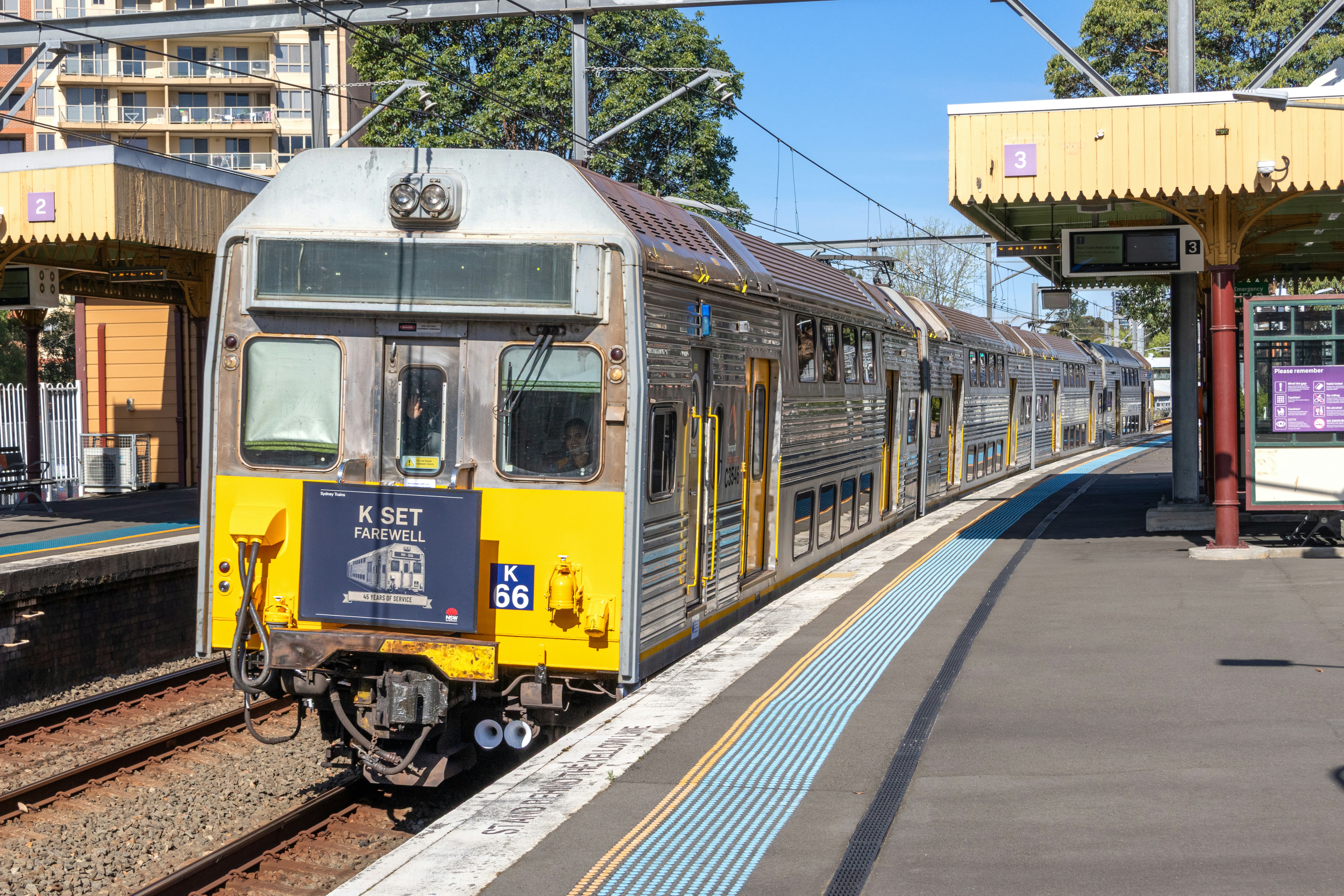 A K set train at a station platform with a farewell sign