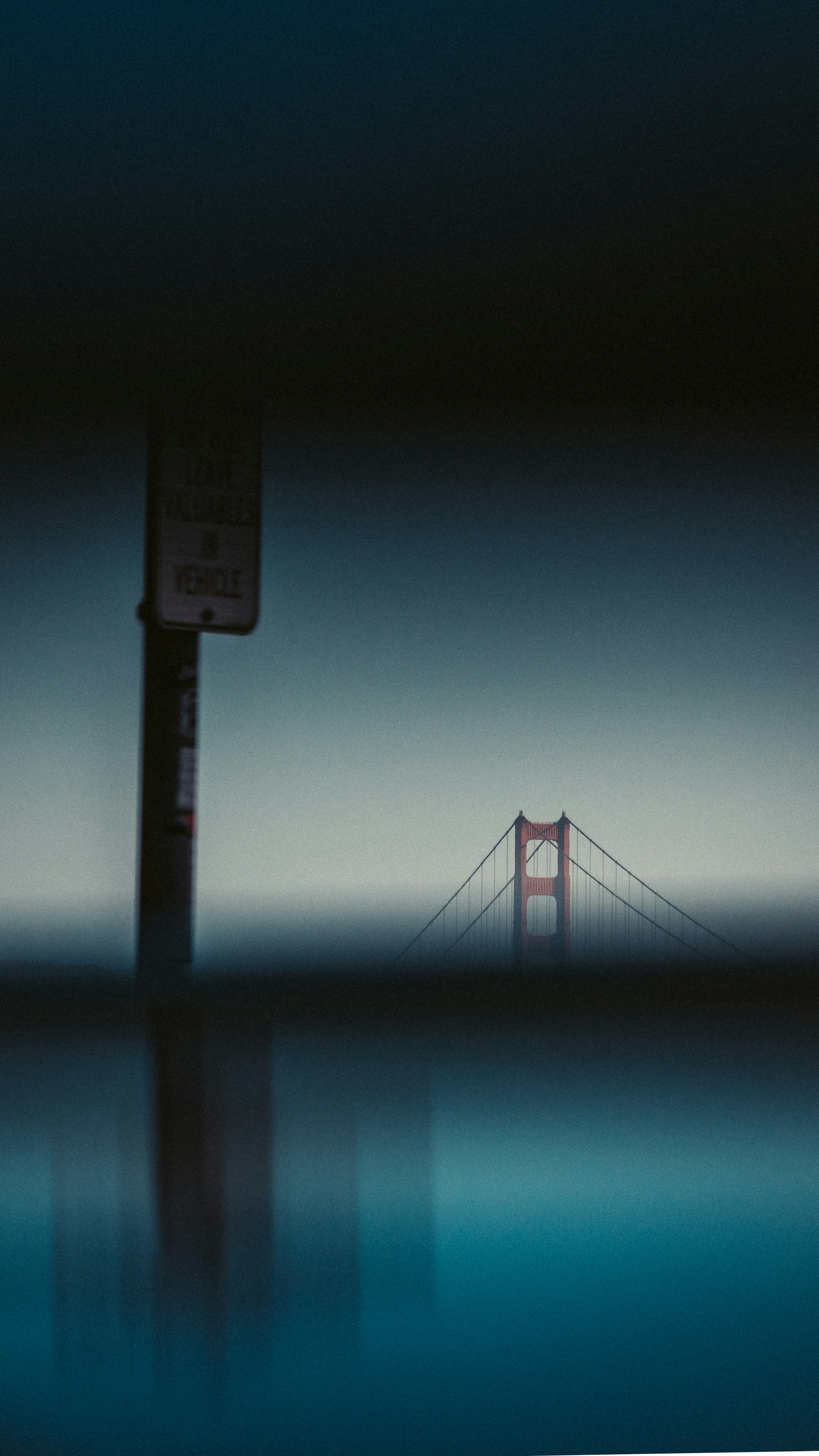 The Golden Gate Bridge in San Francisco seen past a blurred warning sign