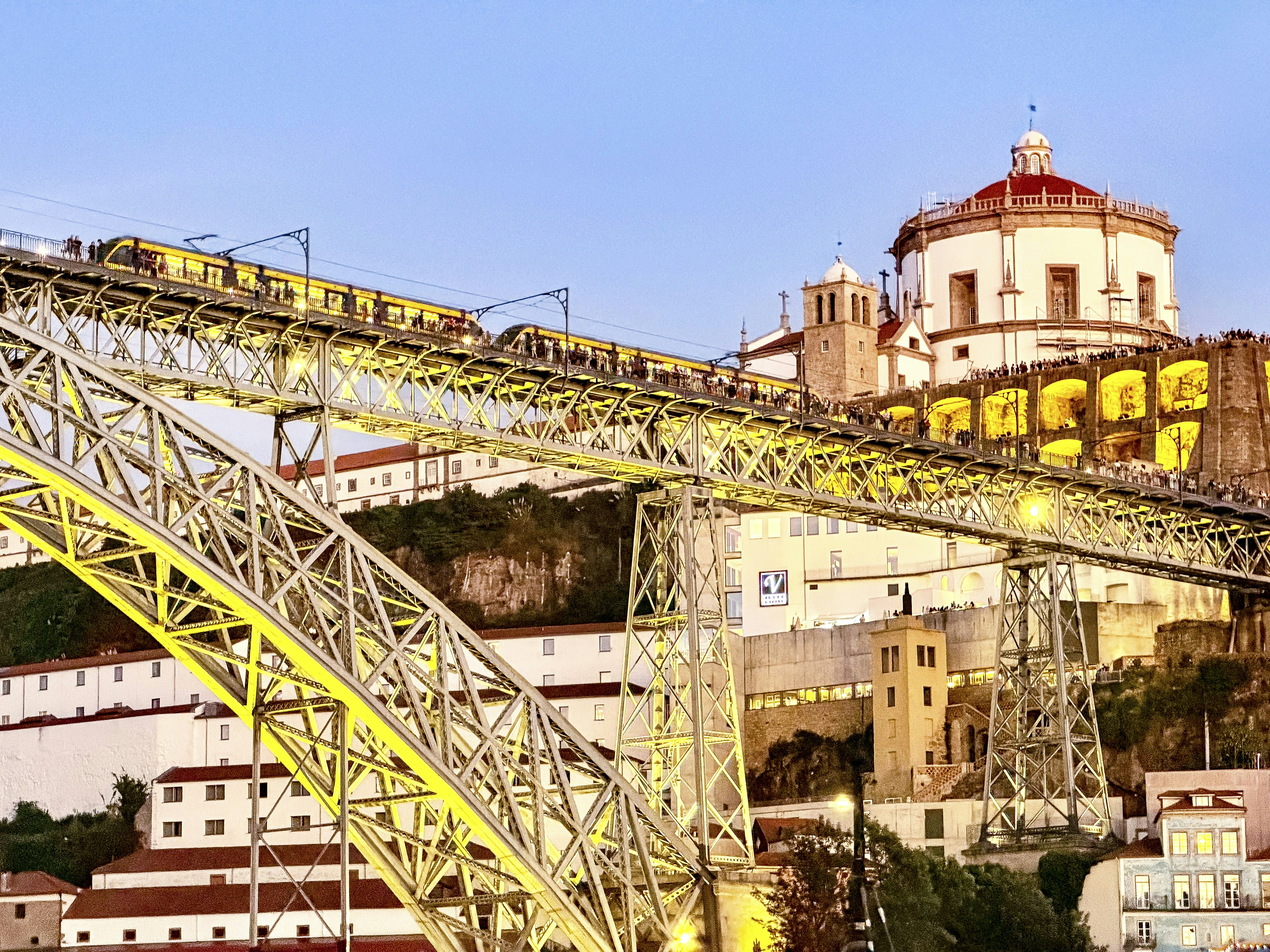 A metro train crossing the Dom Luis I bridge above Porto at golden hour