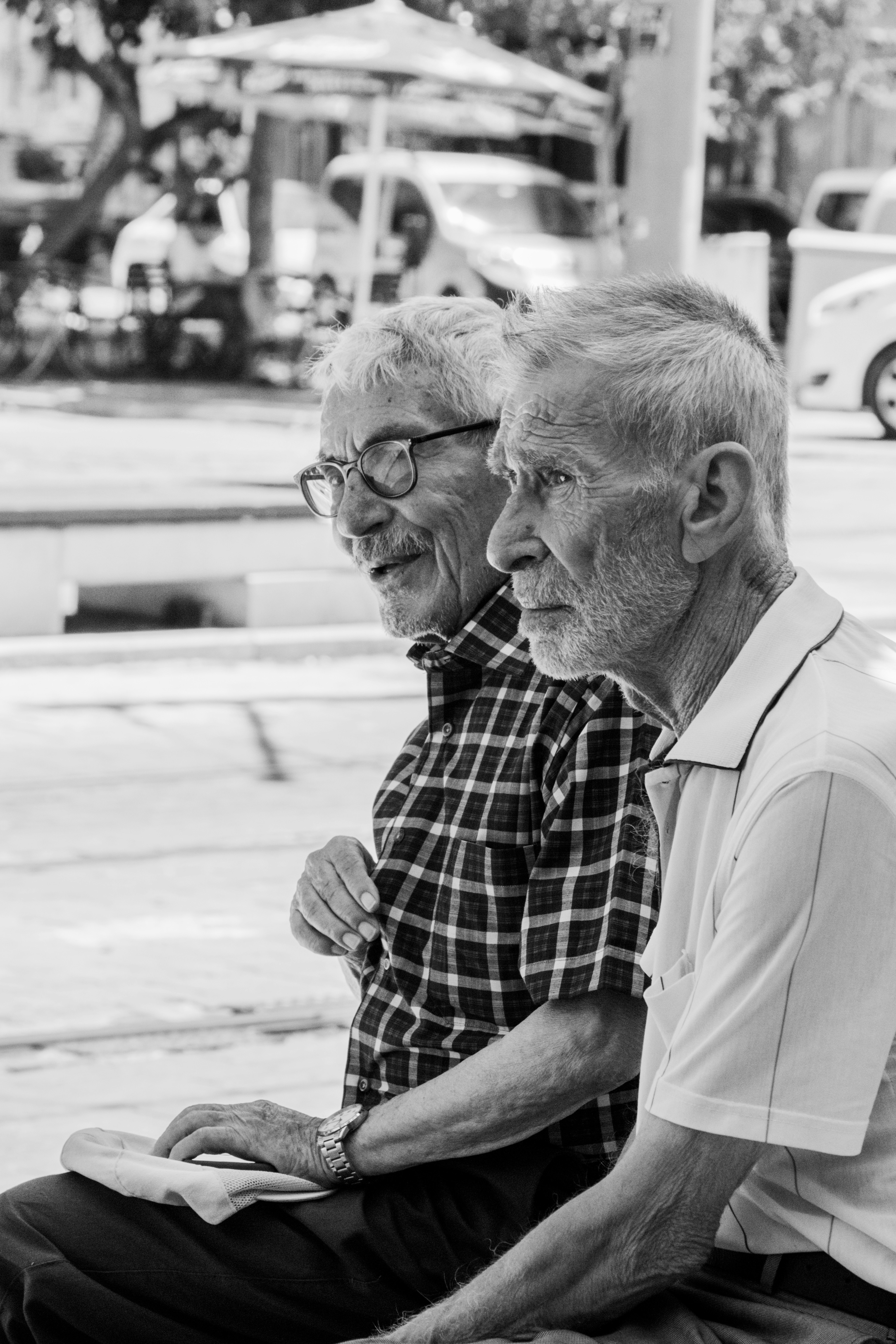 Two elderly men sitting together outdoors in a black and white photograph