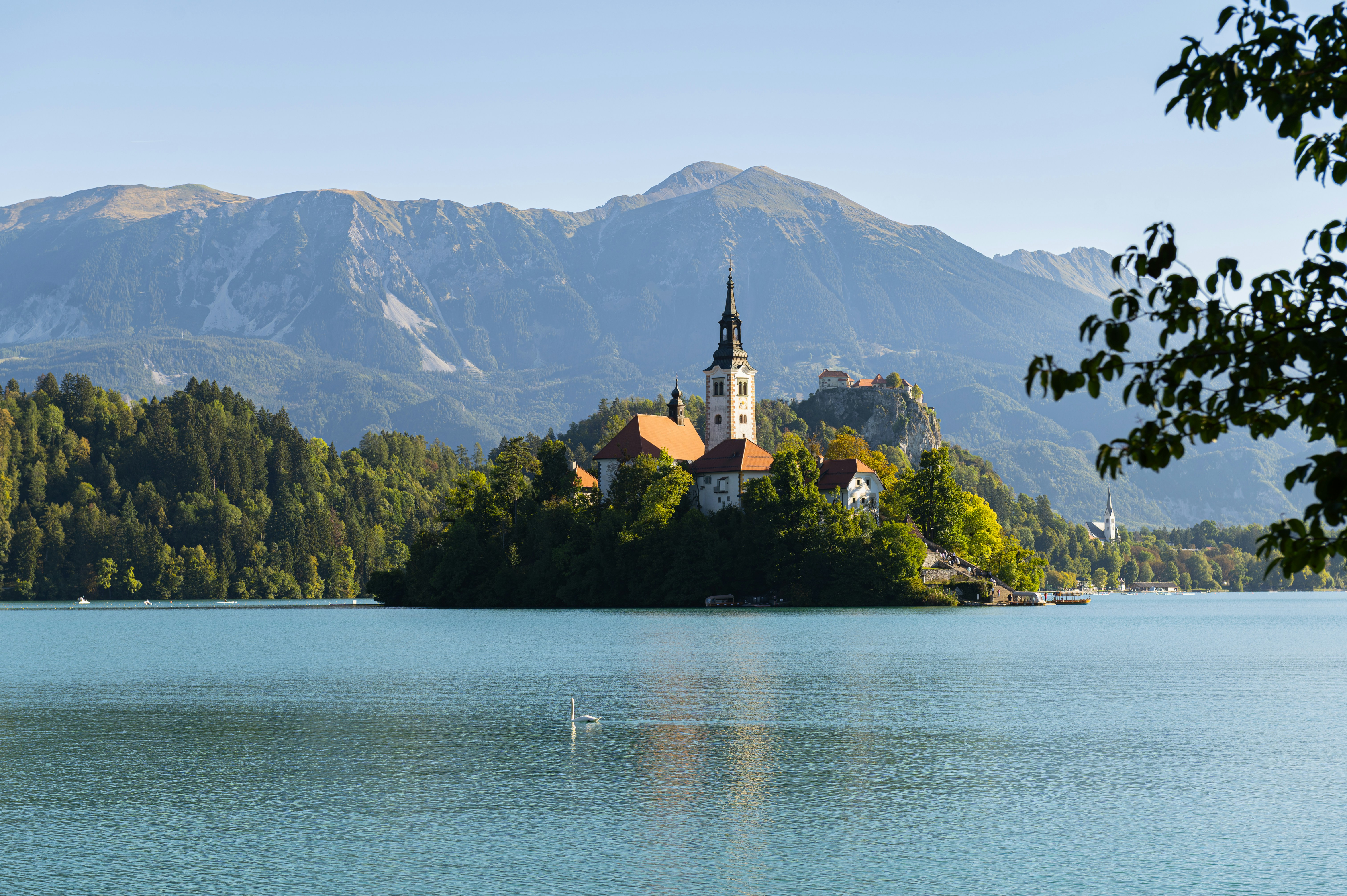 A church on a small island in Lake Bled with mountains in the background