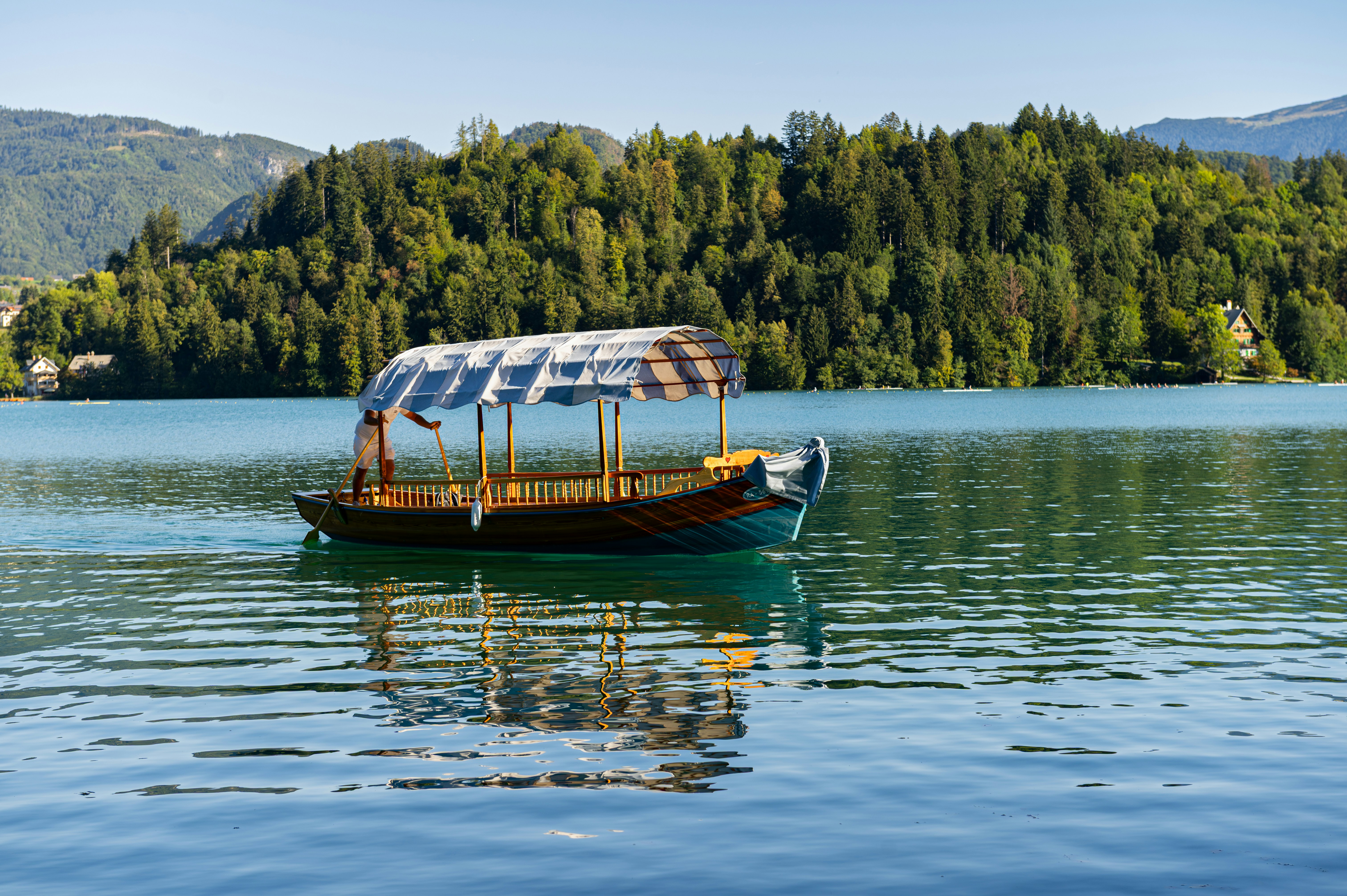 A person rowing a traditional pletna boat on Lake Bled in Slovenia