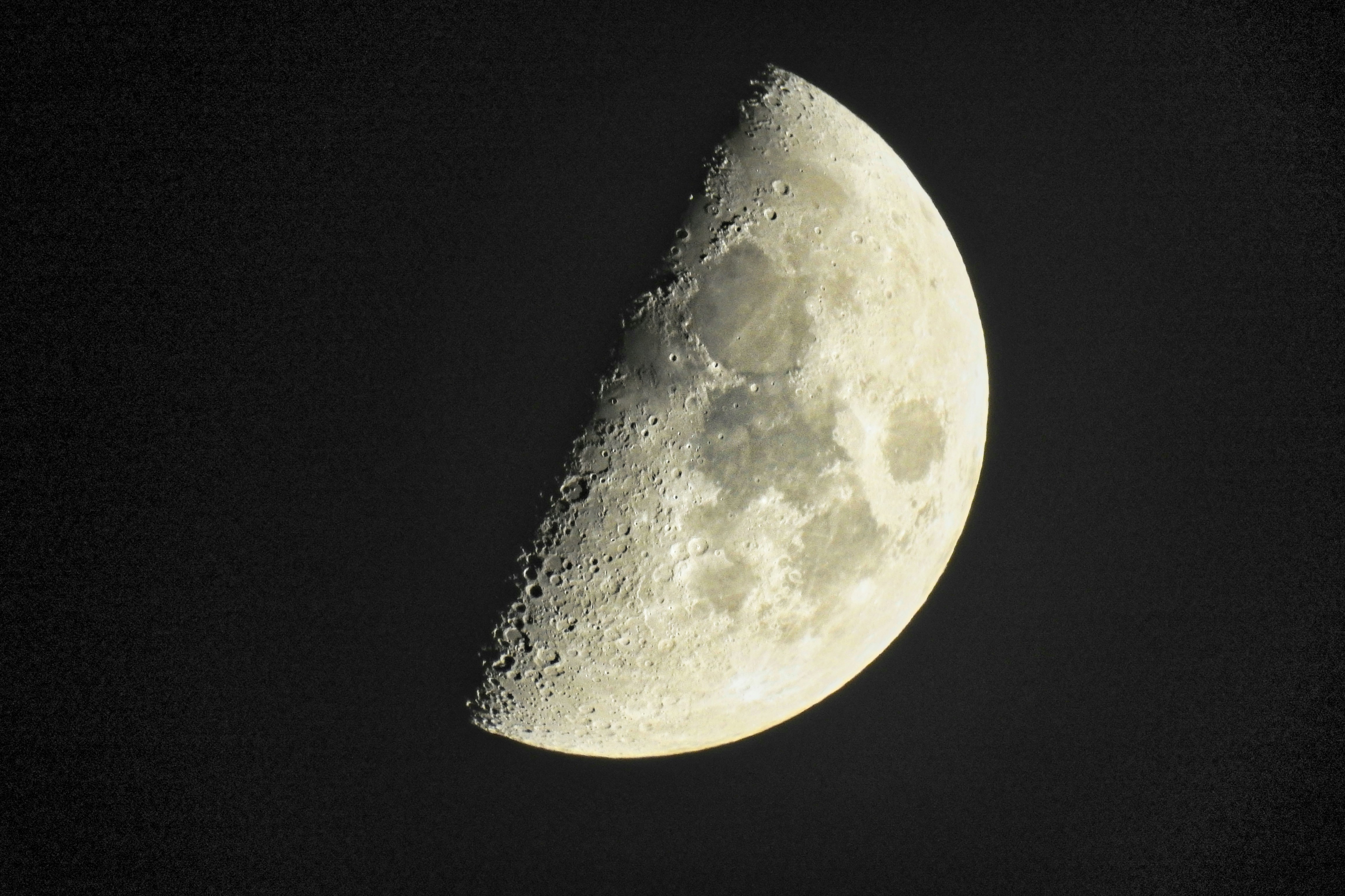 Uma lua gibosa crescente mostrando crateras e marias lunares contra um céu negro
