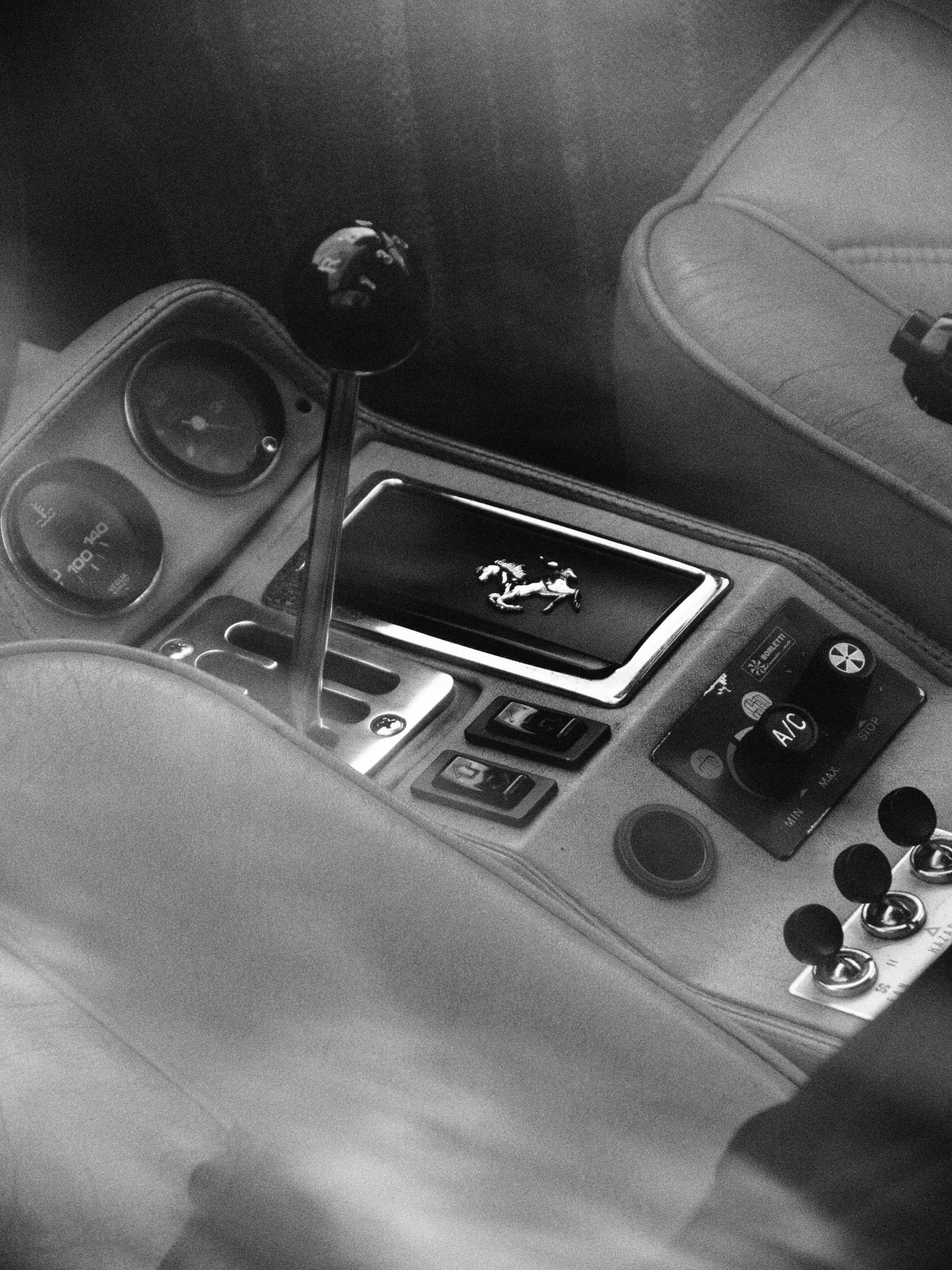 A manual gear shifter and center console inside a vintage sports car