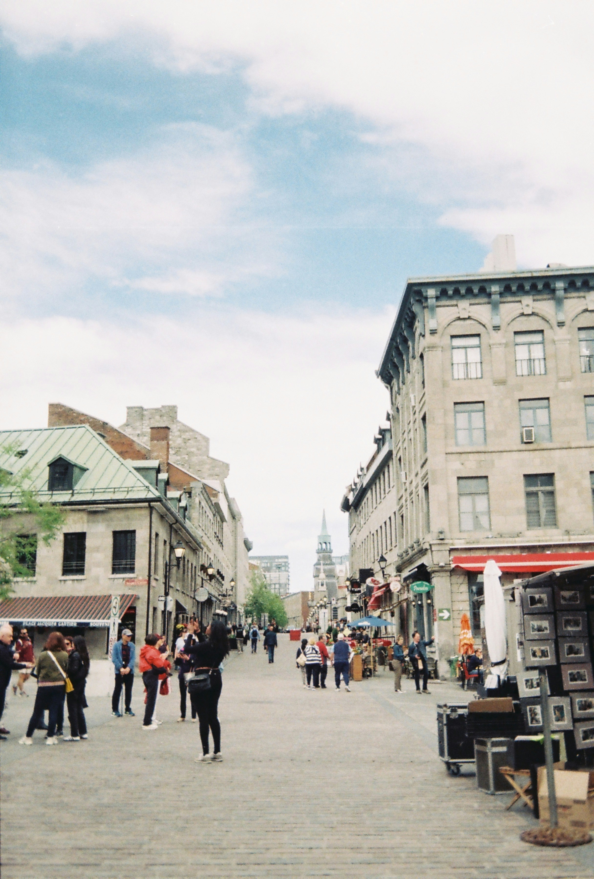 People walking on a cobblestone street in Old Montreal with historic stone buildings