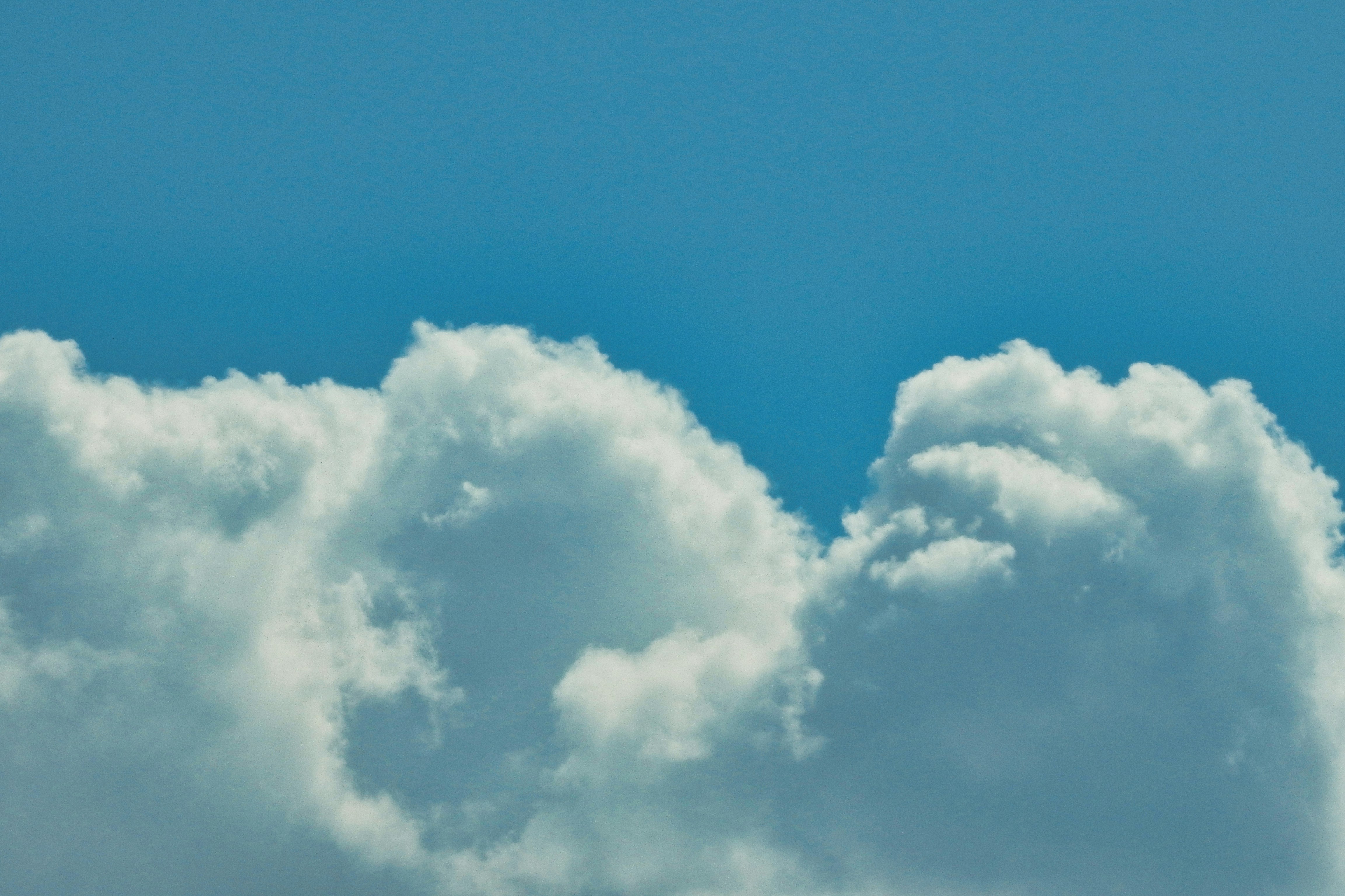 Fluffy white cumulus clouds against a clear blue sky