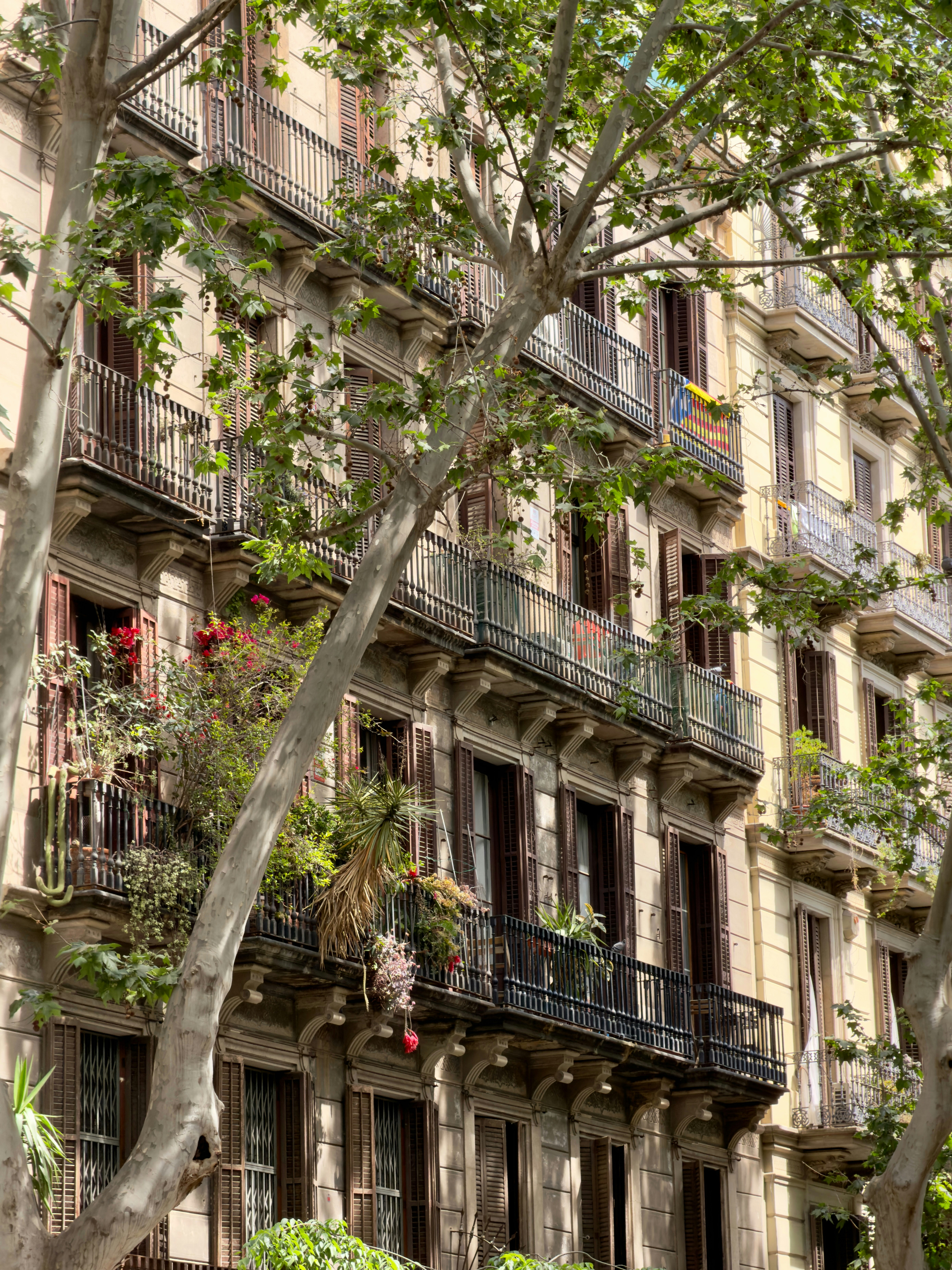 Apartment building facade with balconies and wooden shutters in Barcelona