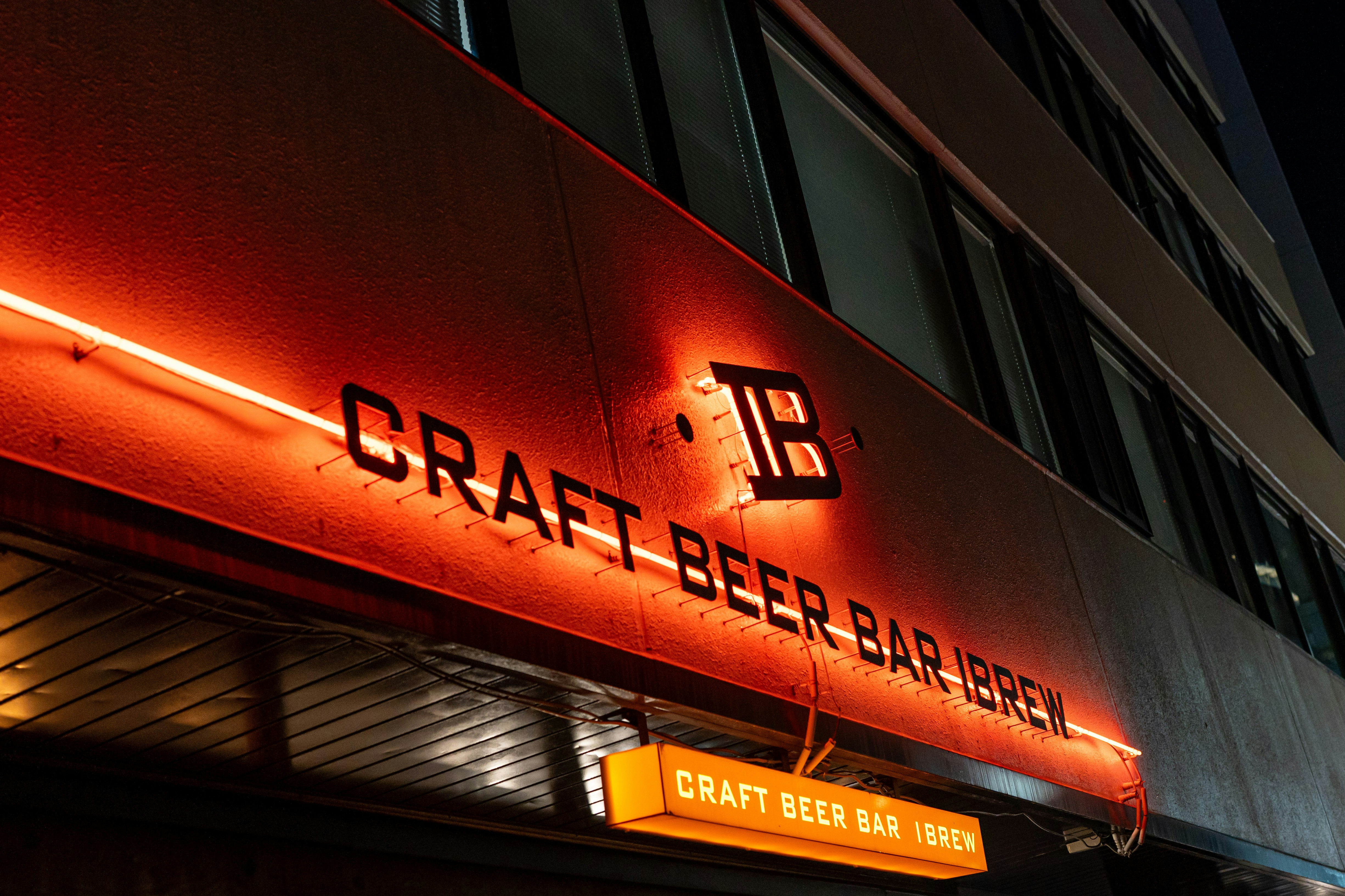 建物の正面には「CRAFT BEER BAR IBREW」と書かれたオレンジ色のネオンサインが掲げられています
