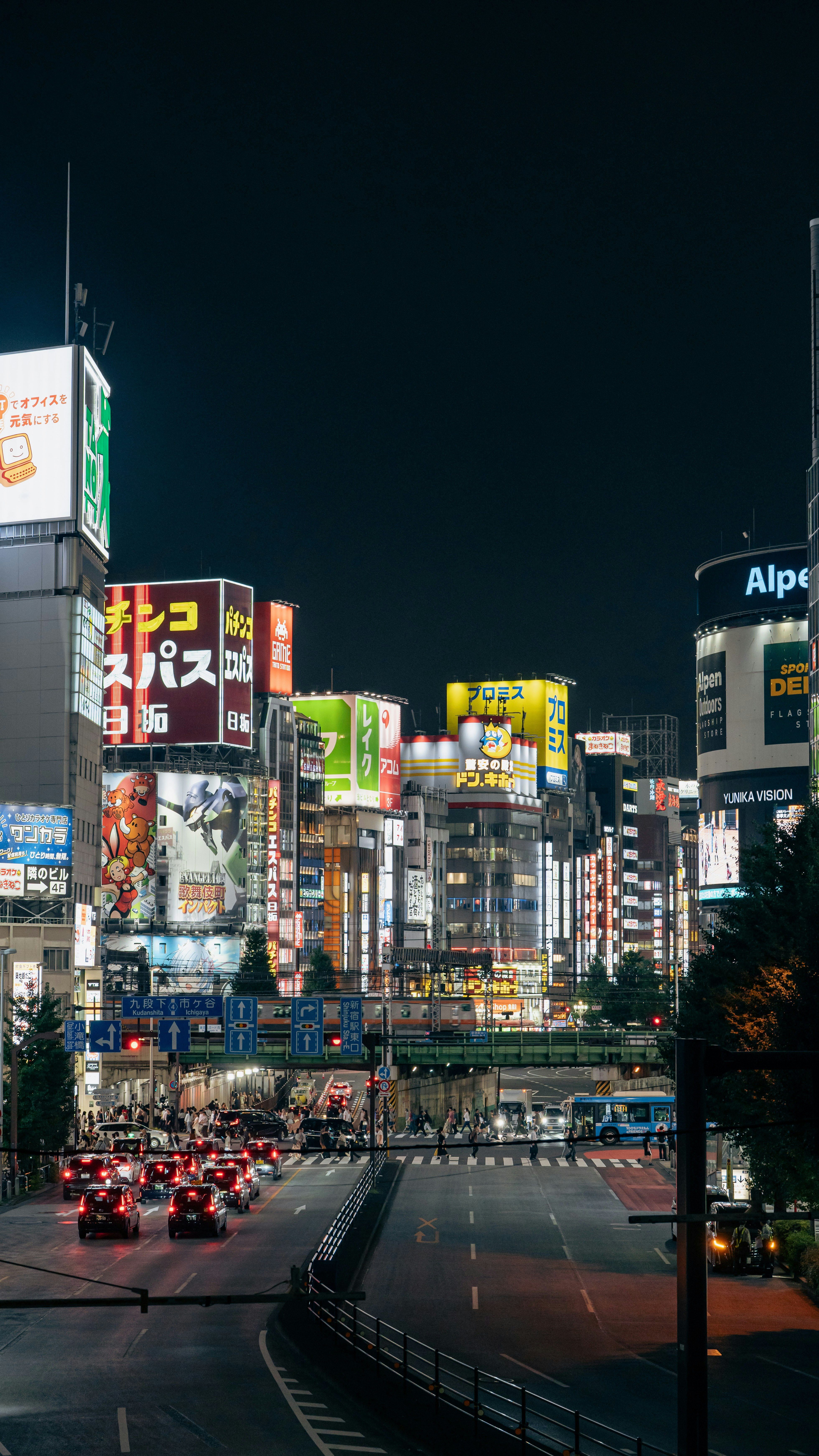 東京の夜の街の通りに灯るネオンの看板と交通
