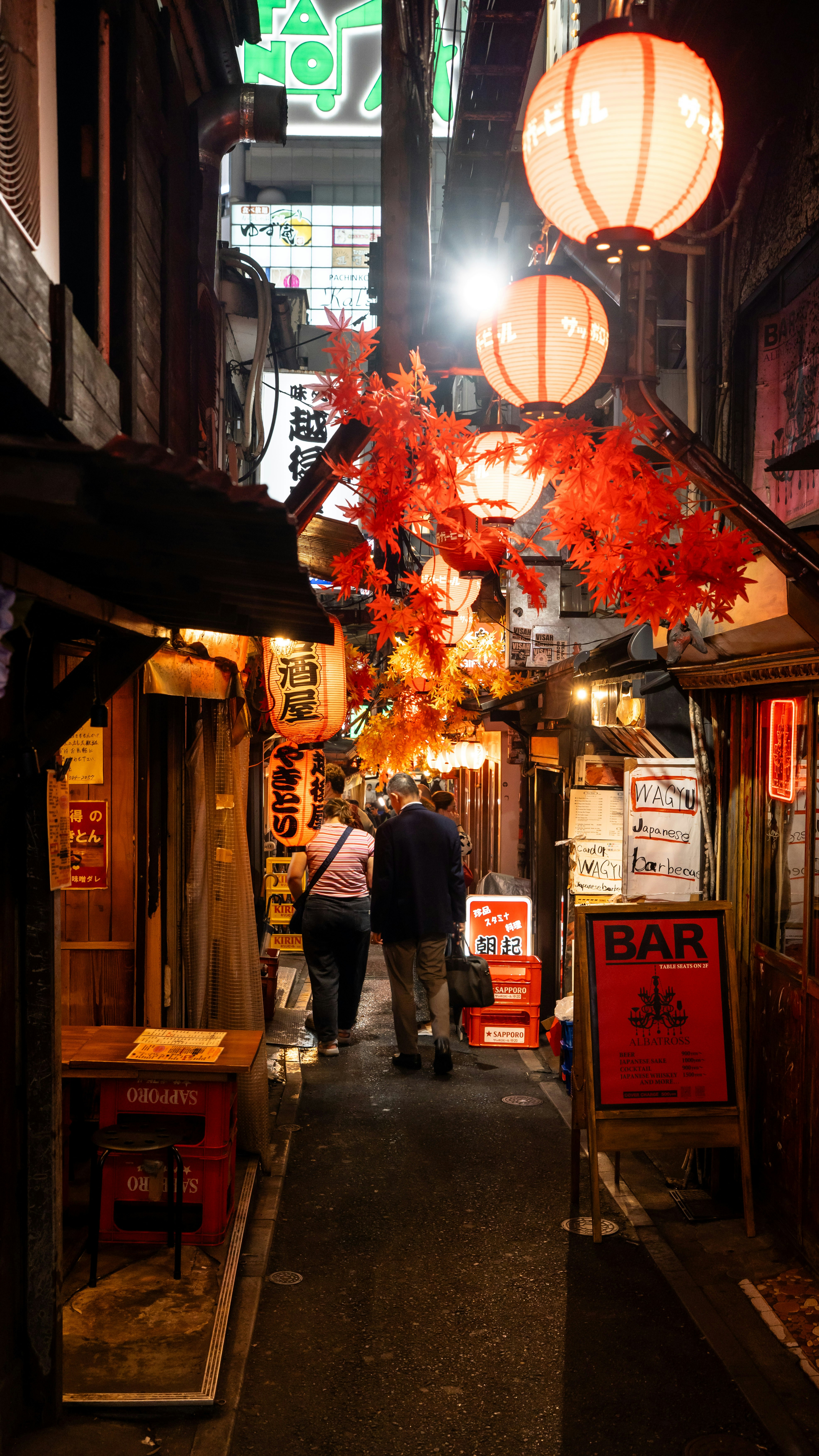 東京の狭い路地を歩く人々。そこには光る紙灯籠が飾られていた