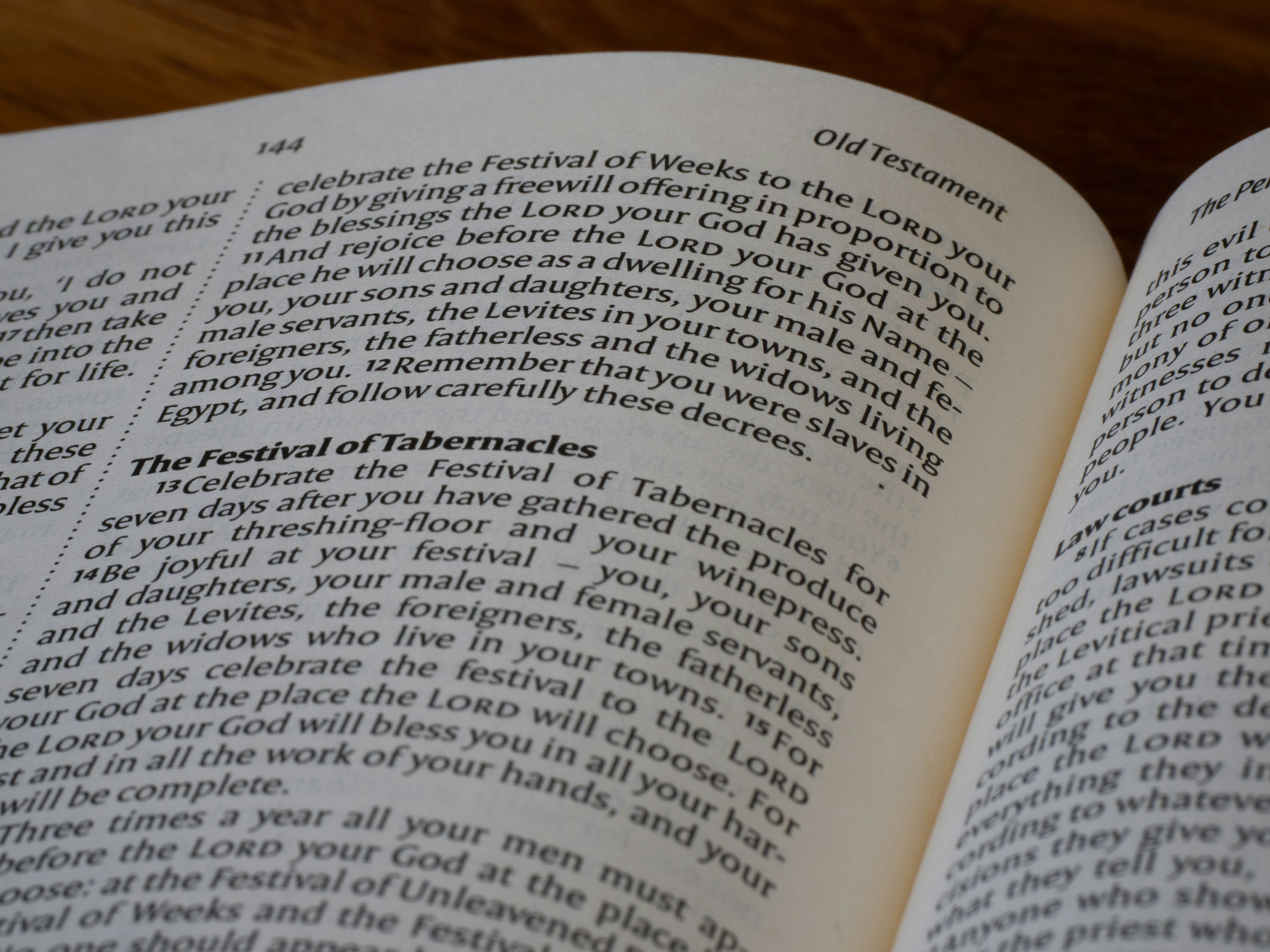 An open book showing printed text from the Old Testament on paper pages