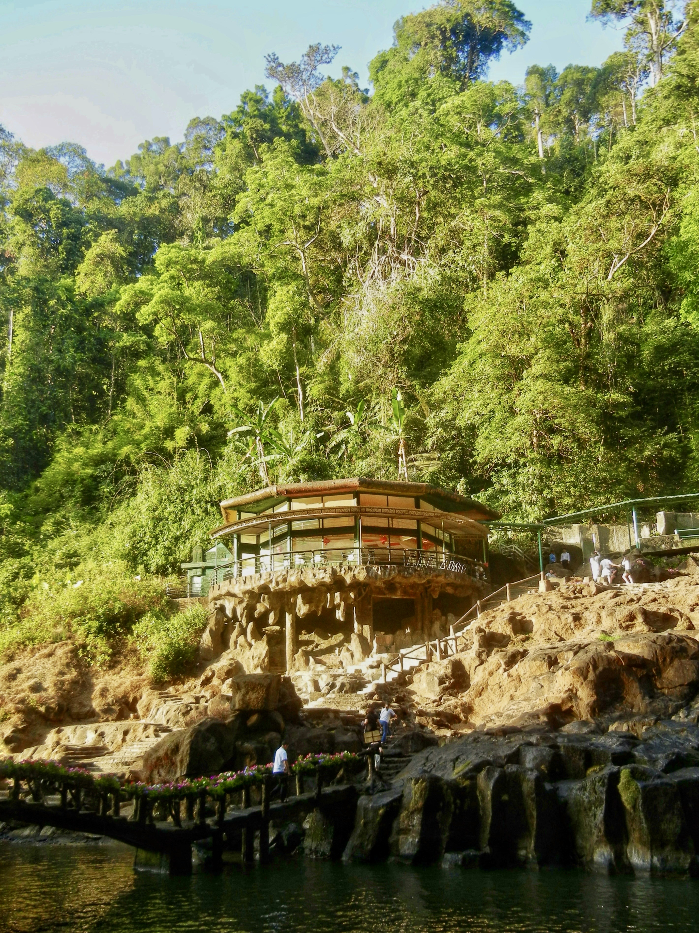 Sebuah restoran yang dibangun di atas batu tebing yang dikelilingi hutan hijau lebat