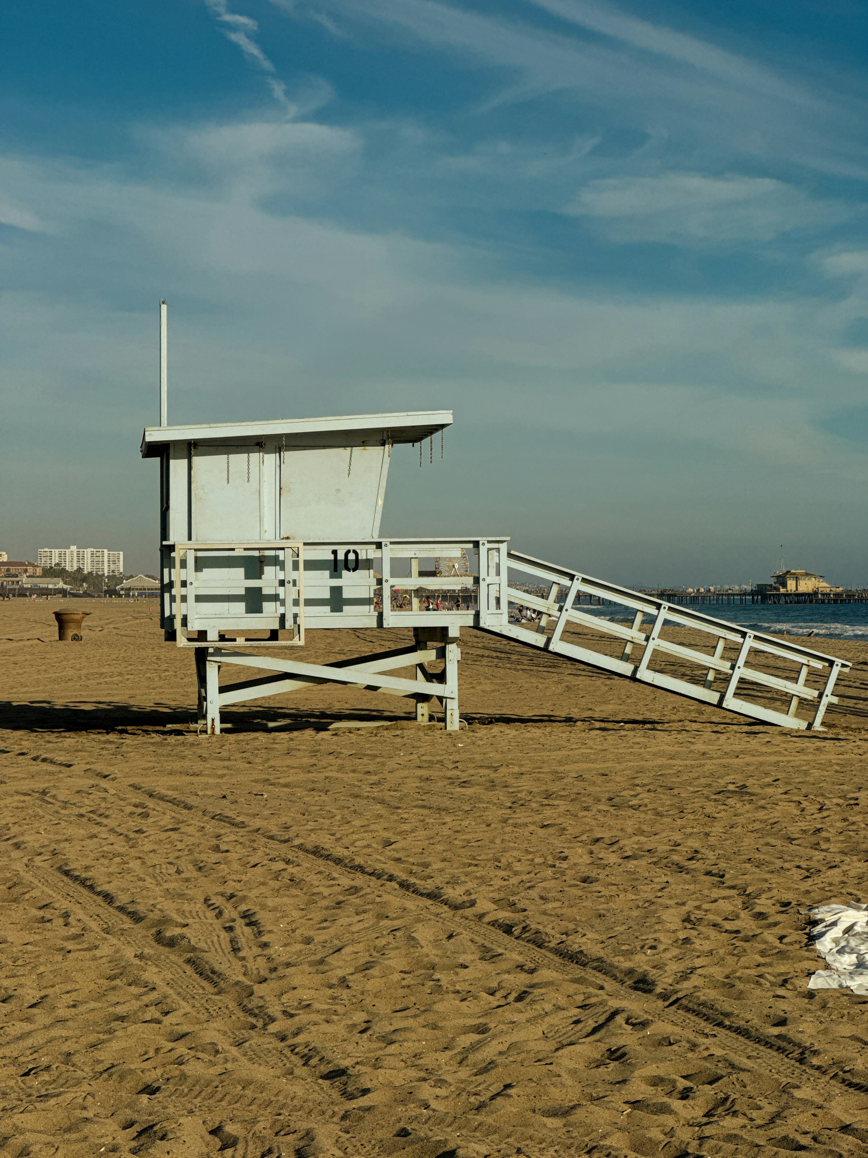 Una torre di bagnini azzurro chiaro numero 10 su una spiaggia sabbiosa sotto un cielo azzurro