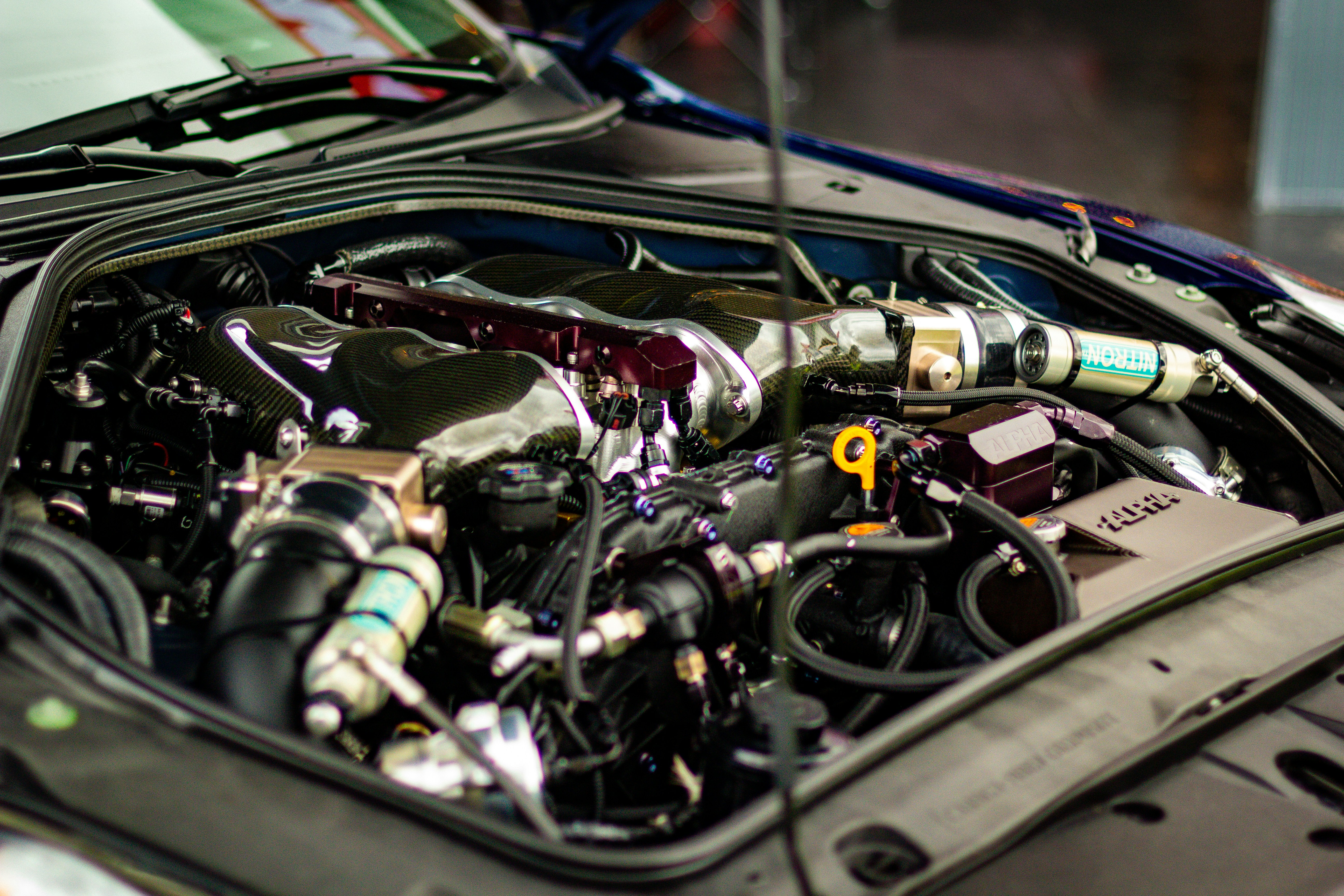 Certified technician inspecting the engine bay and suspension of a pre-owned vehicle