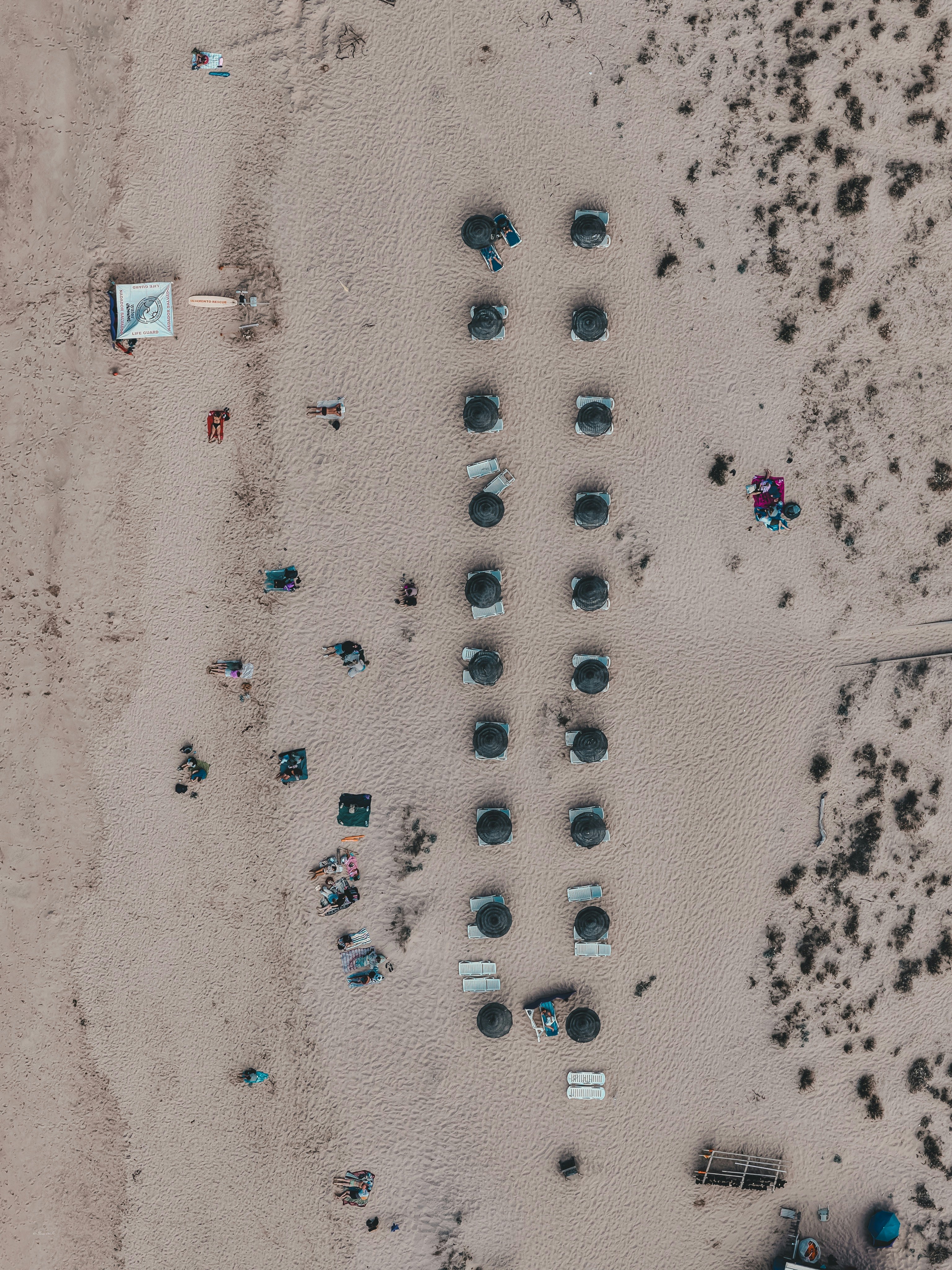 Aerial view of beach umbrellas and sun loungers on a sandy beach