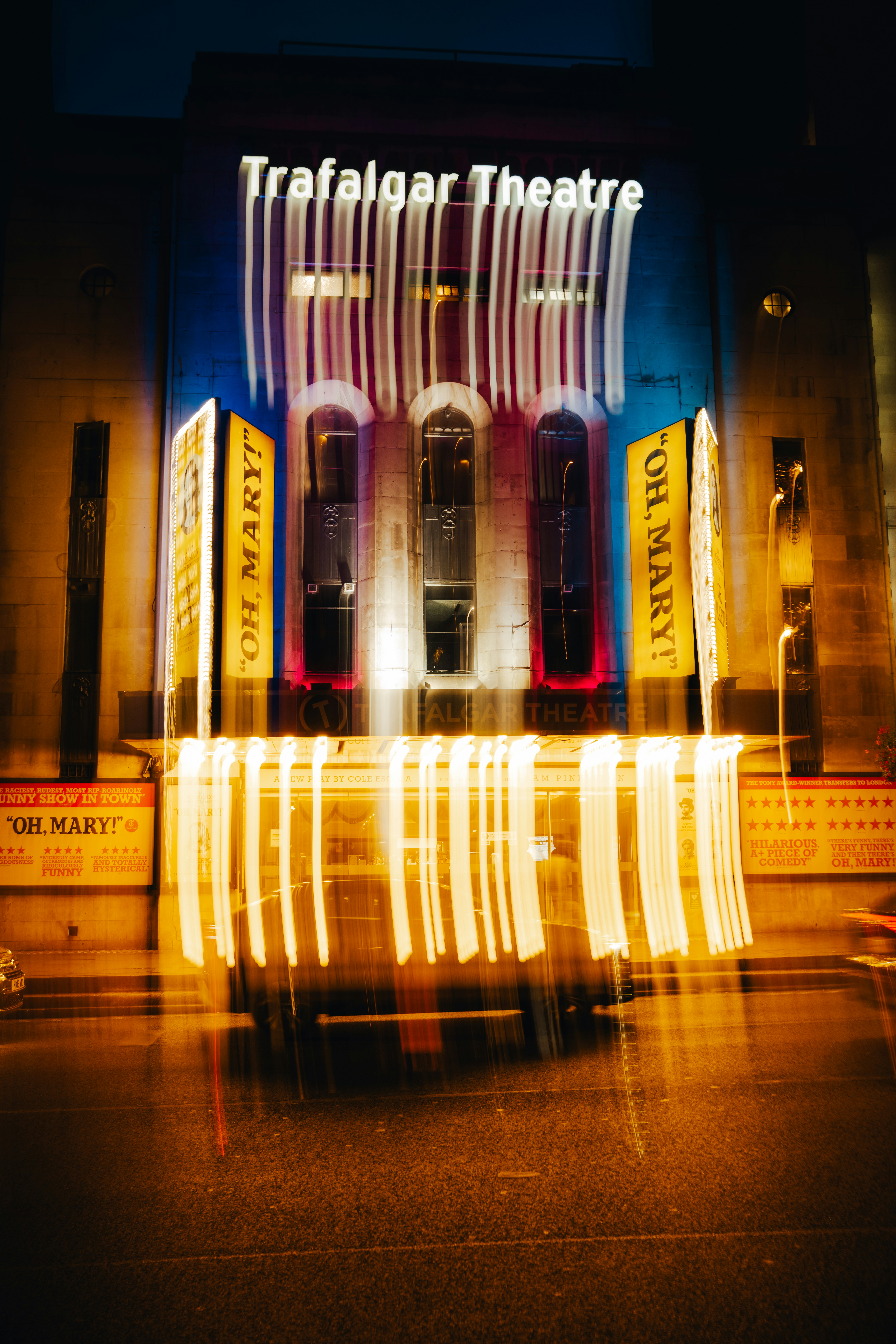 The Trafalgar Theatre facade at night with long exposure light trails from passing traffic