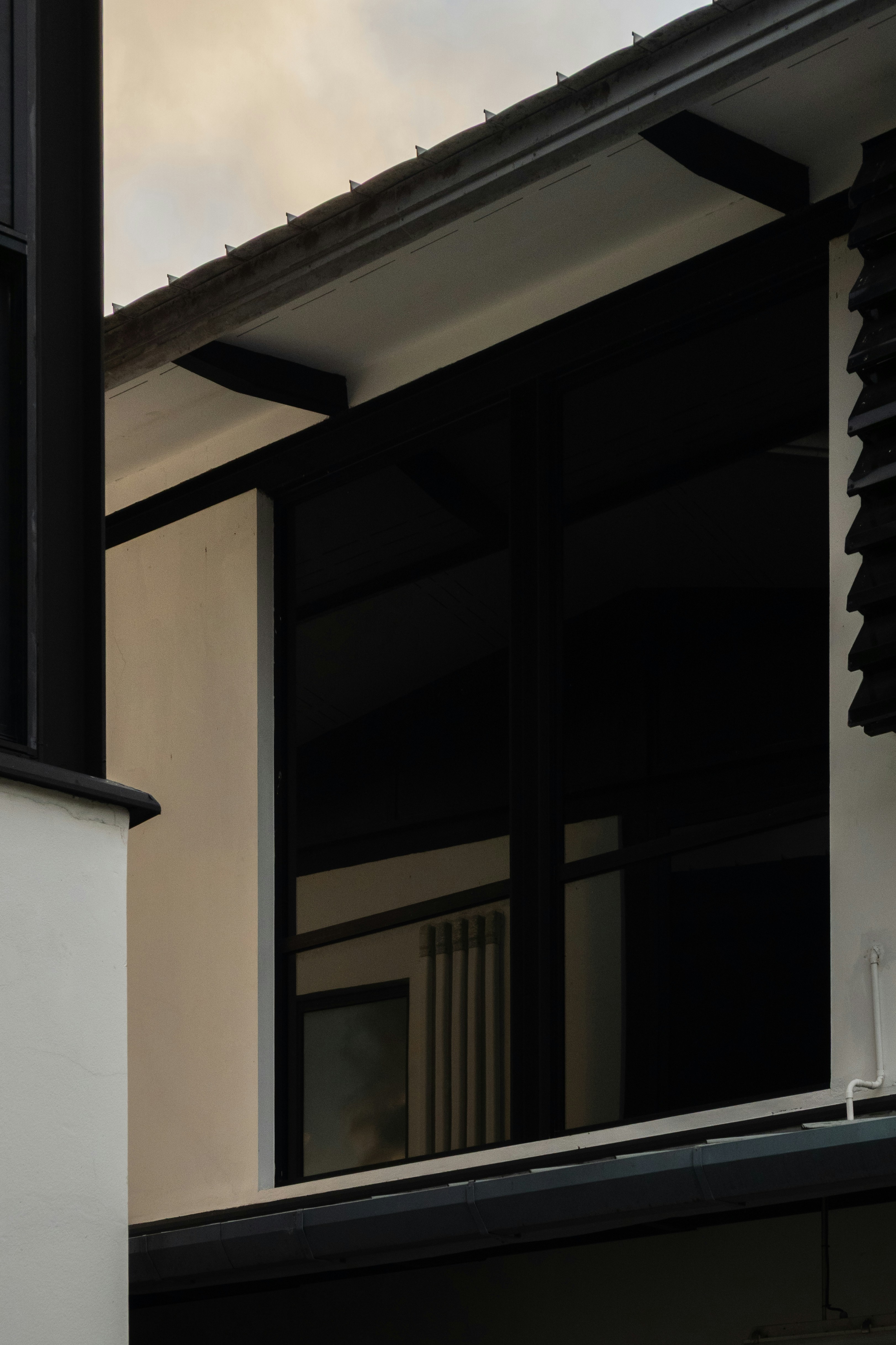 A modern building exterior with white walls and black window frames