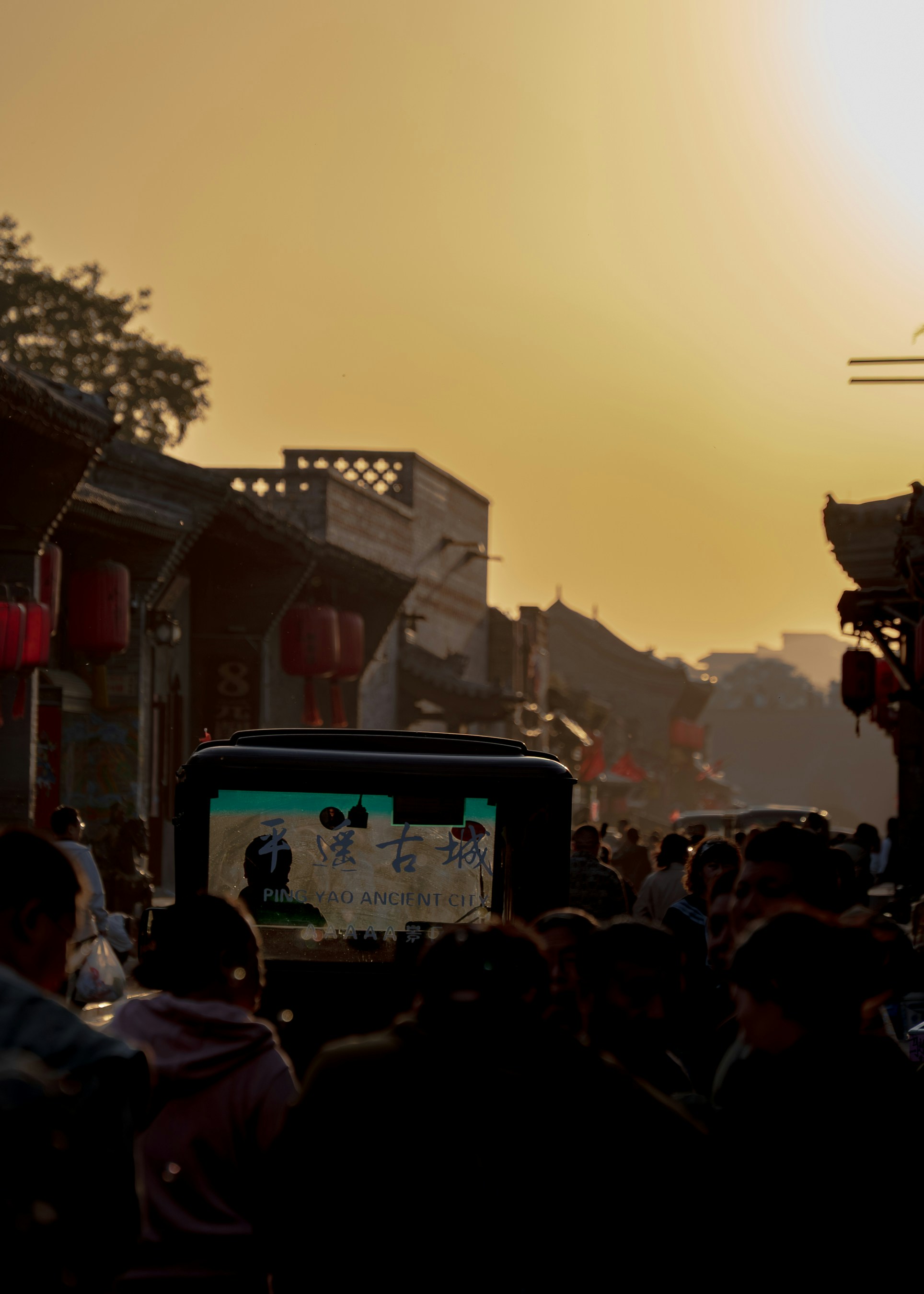 A crowd of people on a street in Ping Yao Ancient City at golden hour