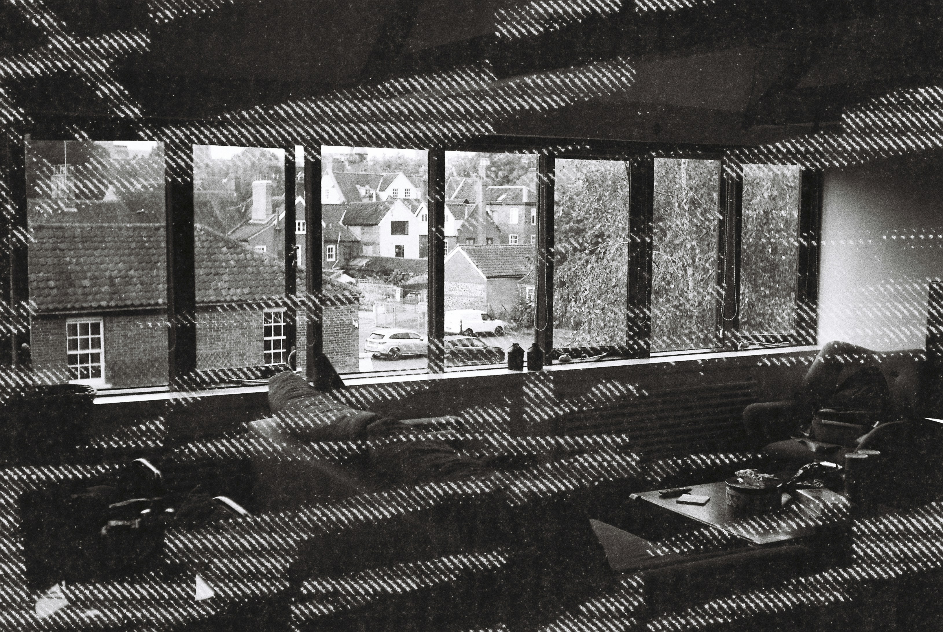 A double exposure of a living room and a view of brick houses