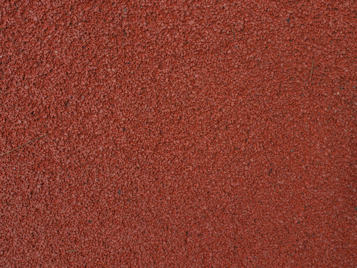 Red synthetic track surface made of rubber granules