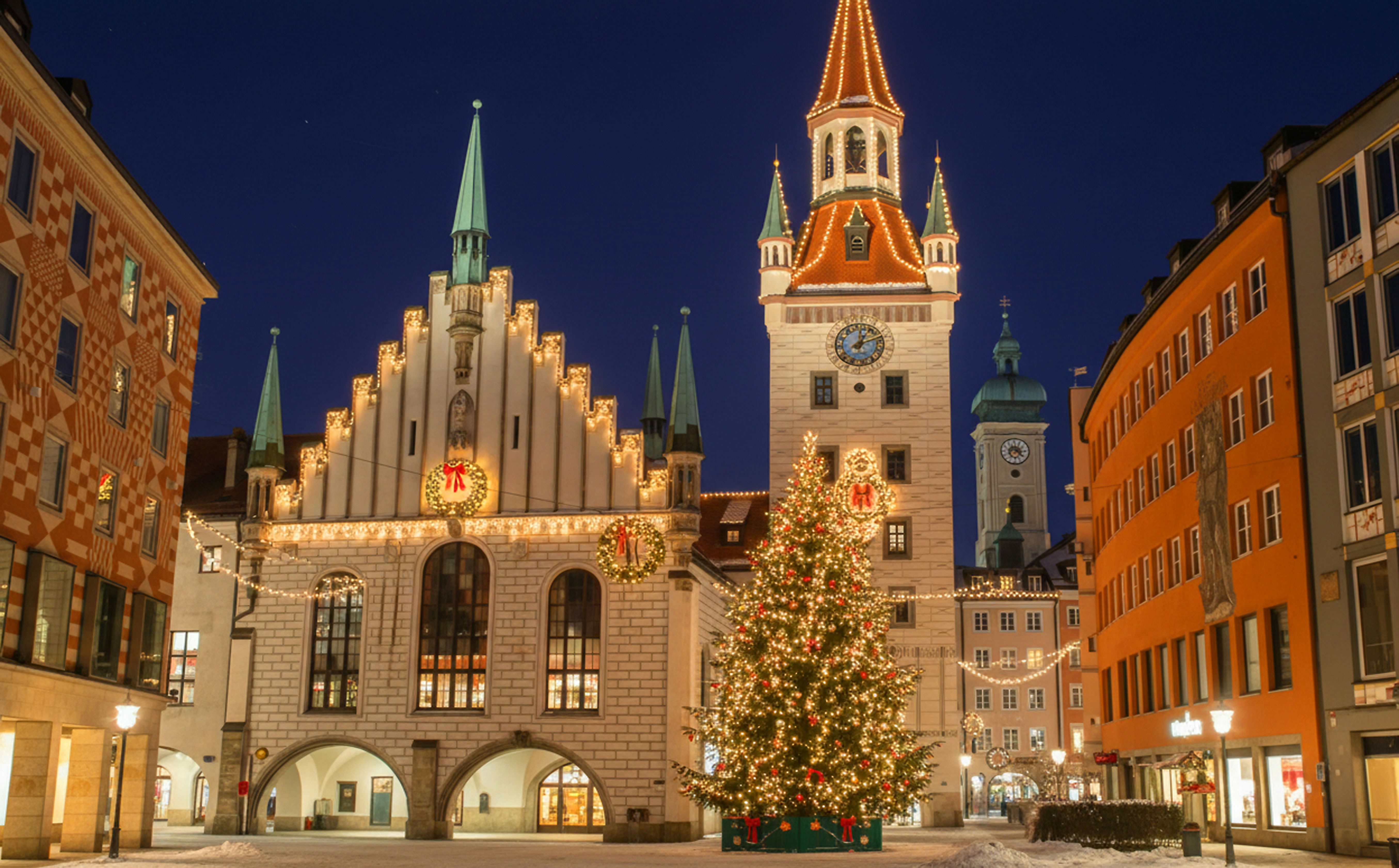 Munich's Old Town Hall facade decorated with wreaths and a large Christmas tree on Marienplatz