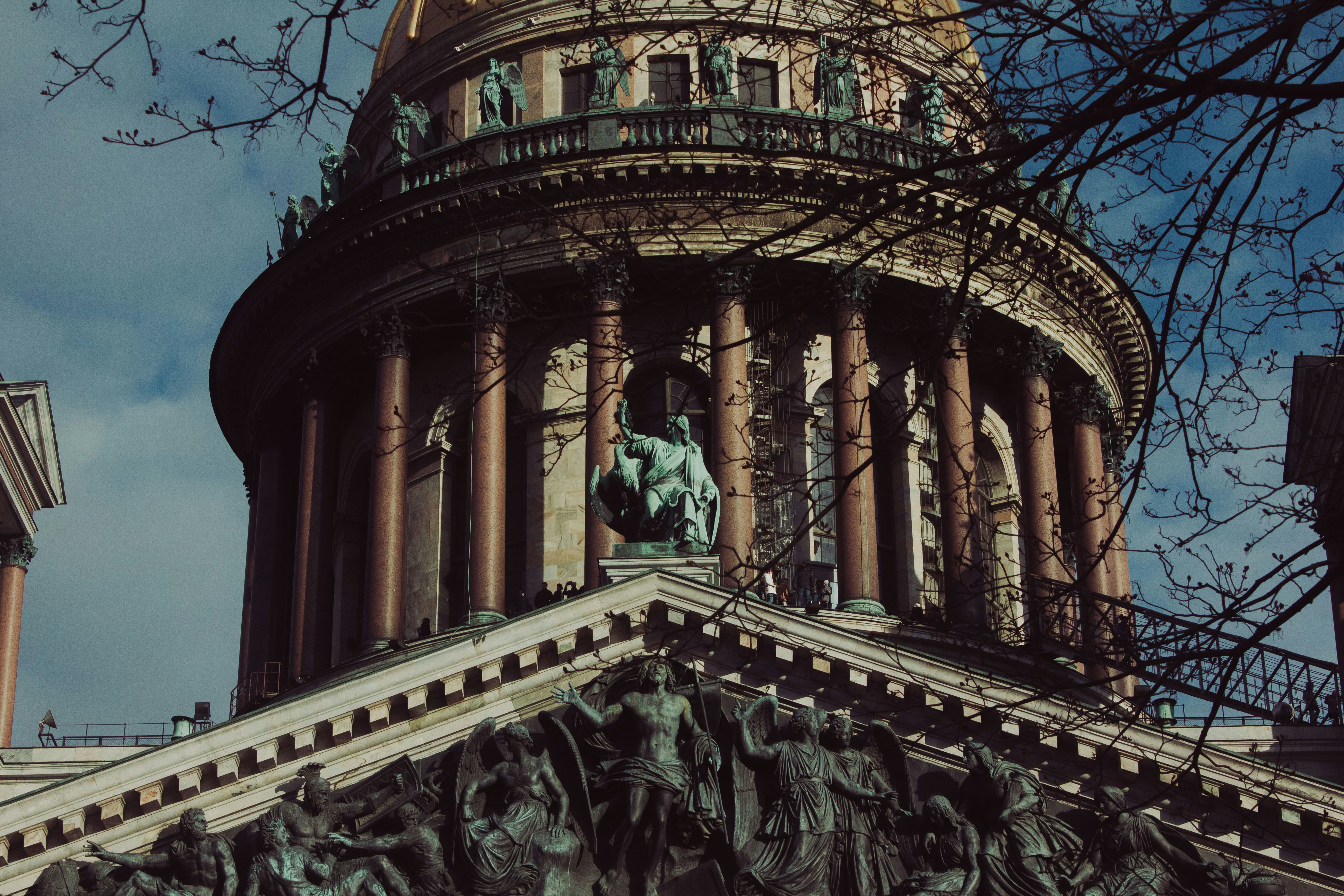 The neoclassical dome and colonnade of Saint Isaac's Cathedral in Saint Petersburg framed by bare tree branches