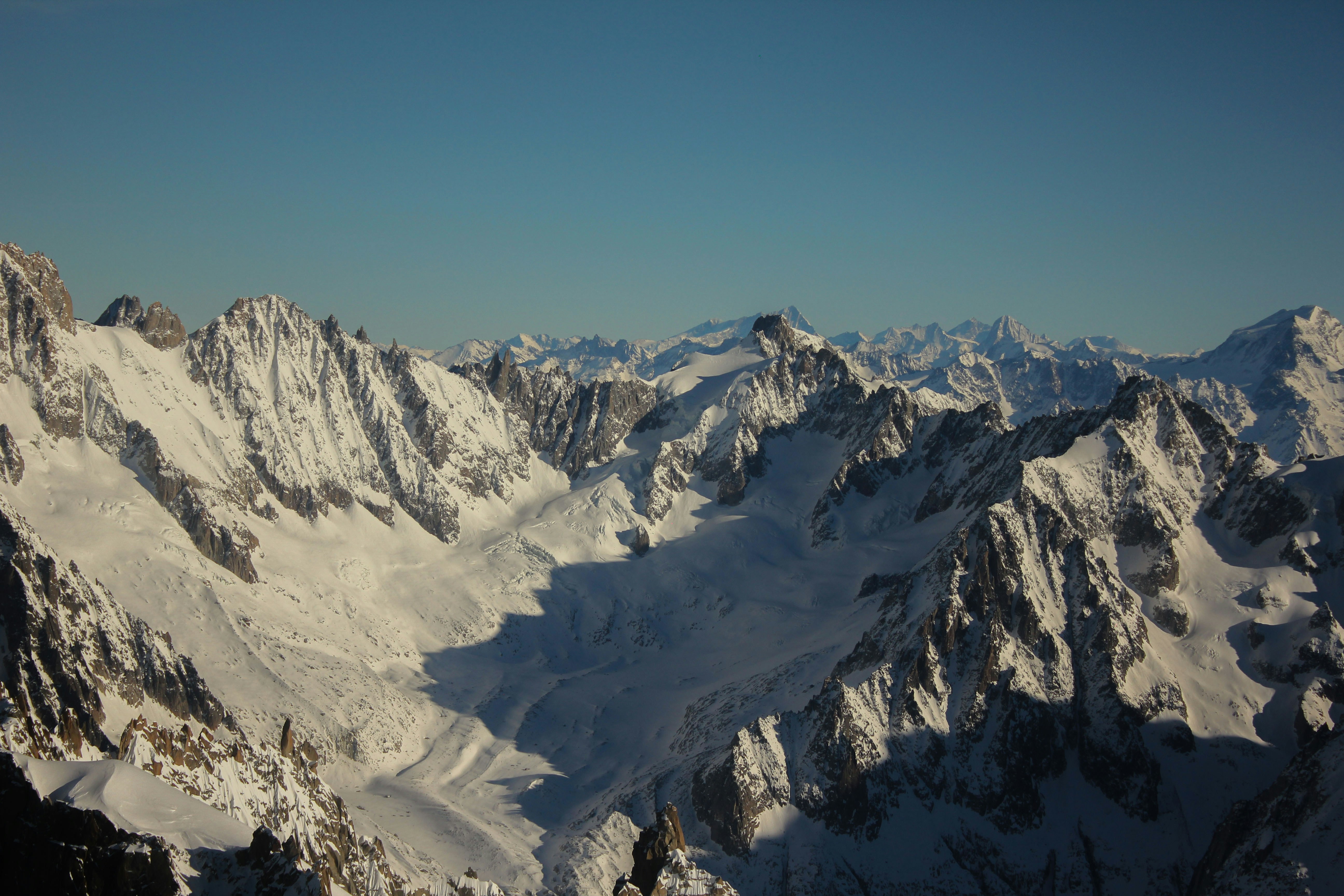 Snow-covered mountain peaks and glaciers under a clear blue sky