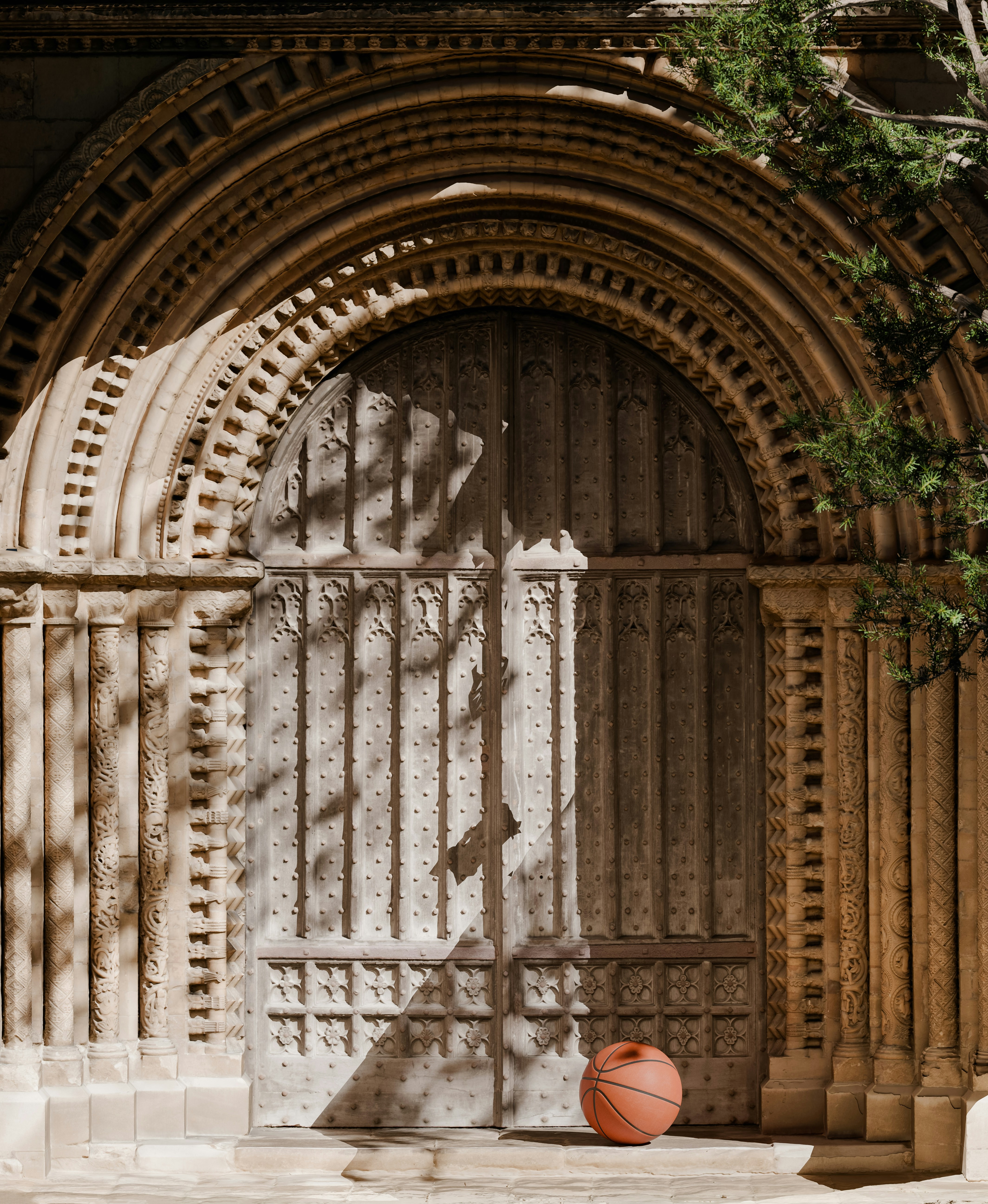 A basketball resting before an ornate arched stone doorway with intricate carvings