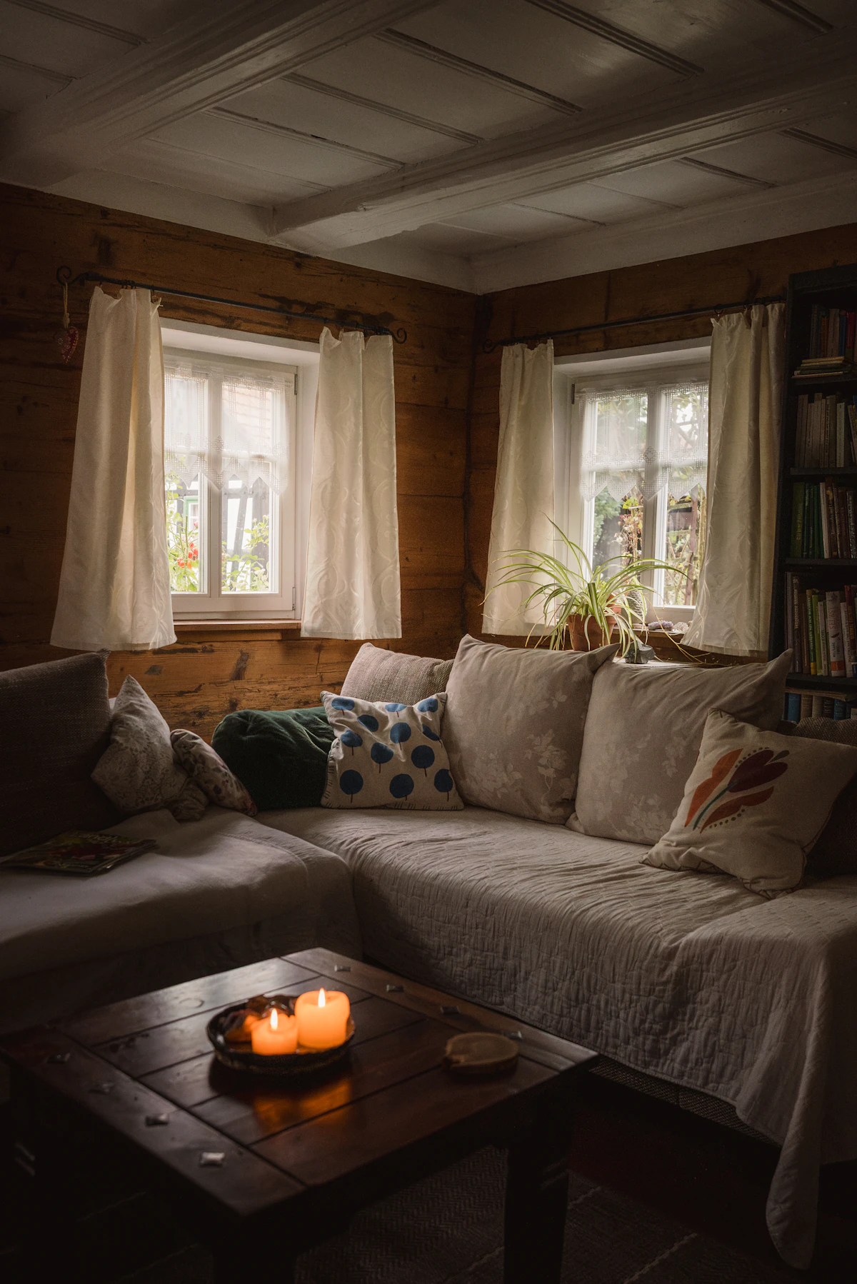 Cozy living room with wooden walls, sofa, and candles