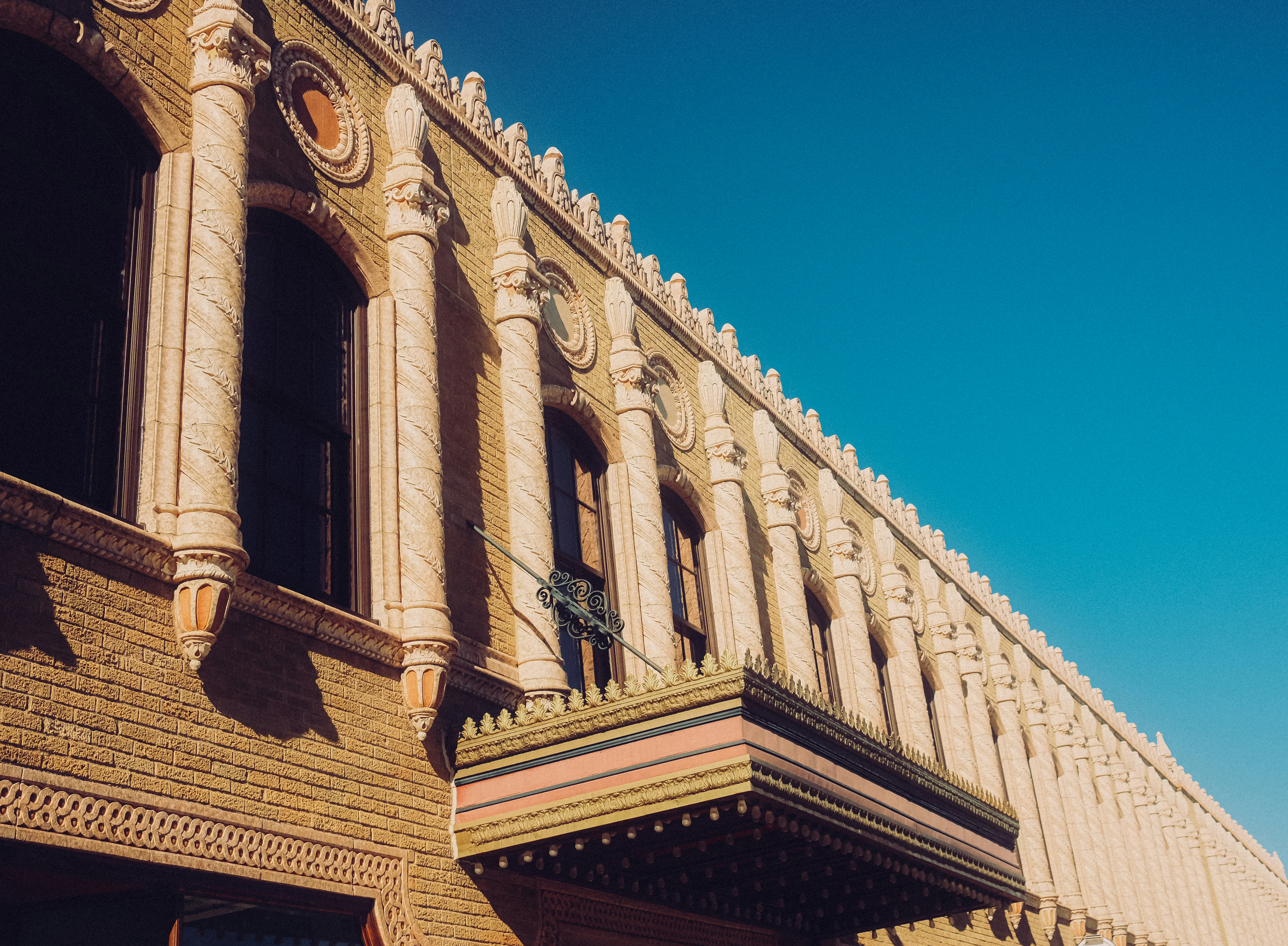 A historic brick building with ornate columns and a marquee under a clear sky