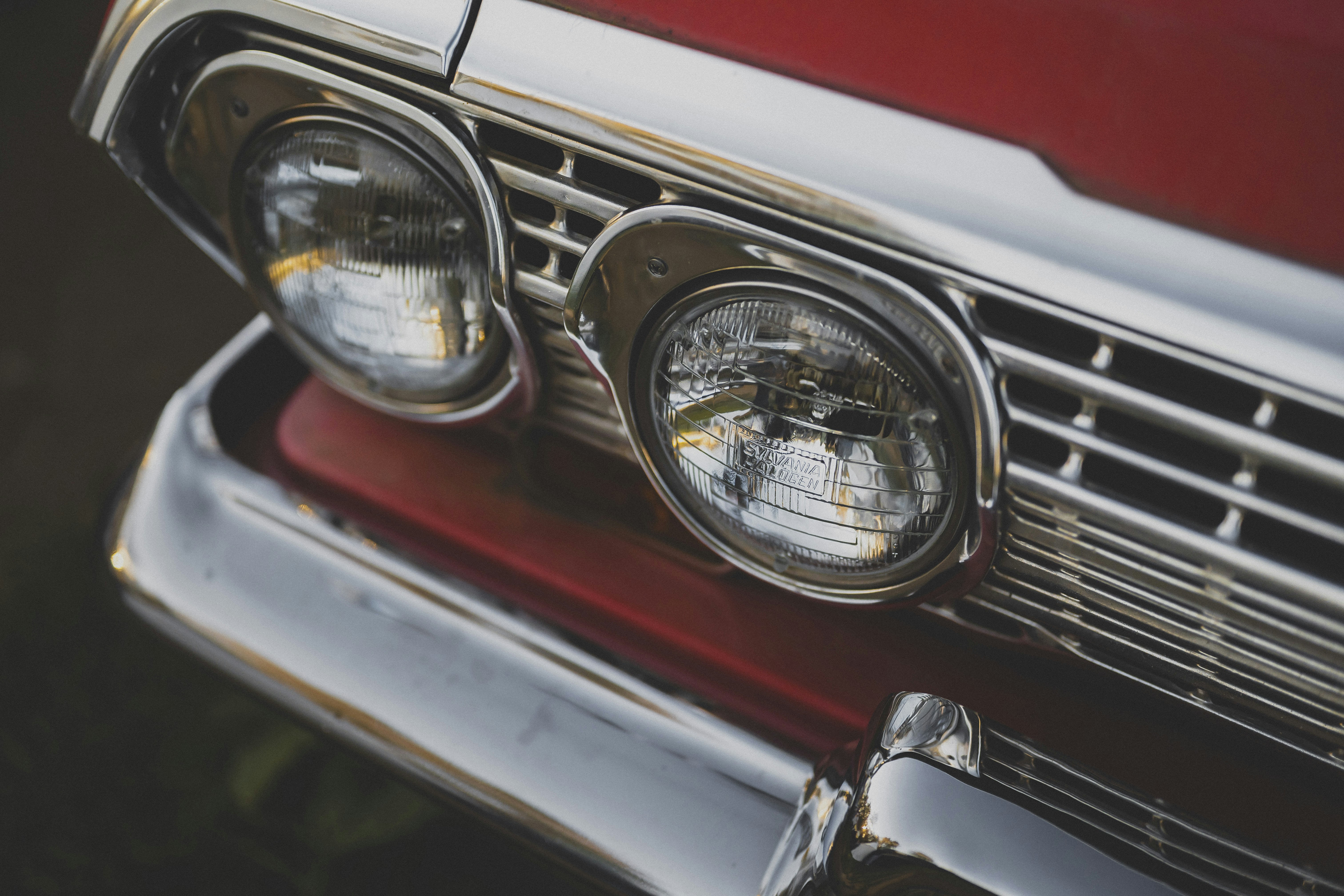 La parrilla cromada y los faros redondos de un coche rojo vintage