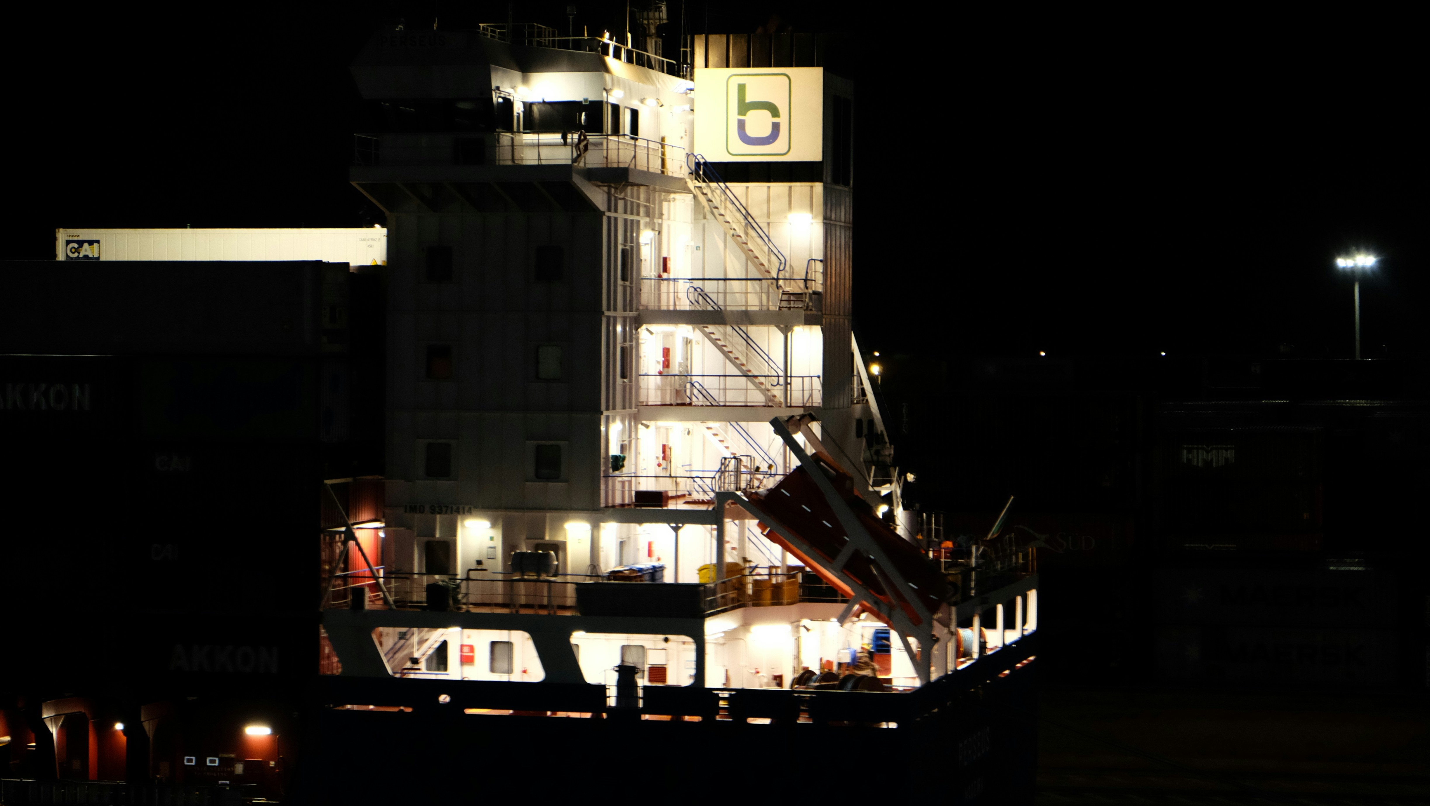 Il ponte illuminato e la sovrastruttura di una nave portacontainer di notte