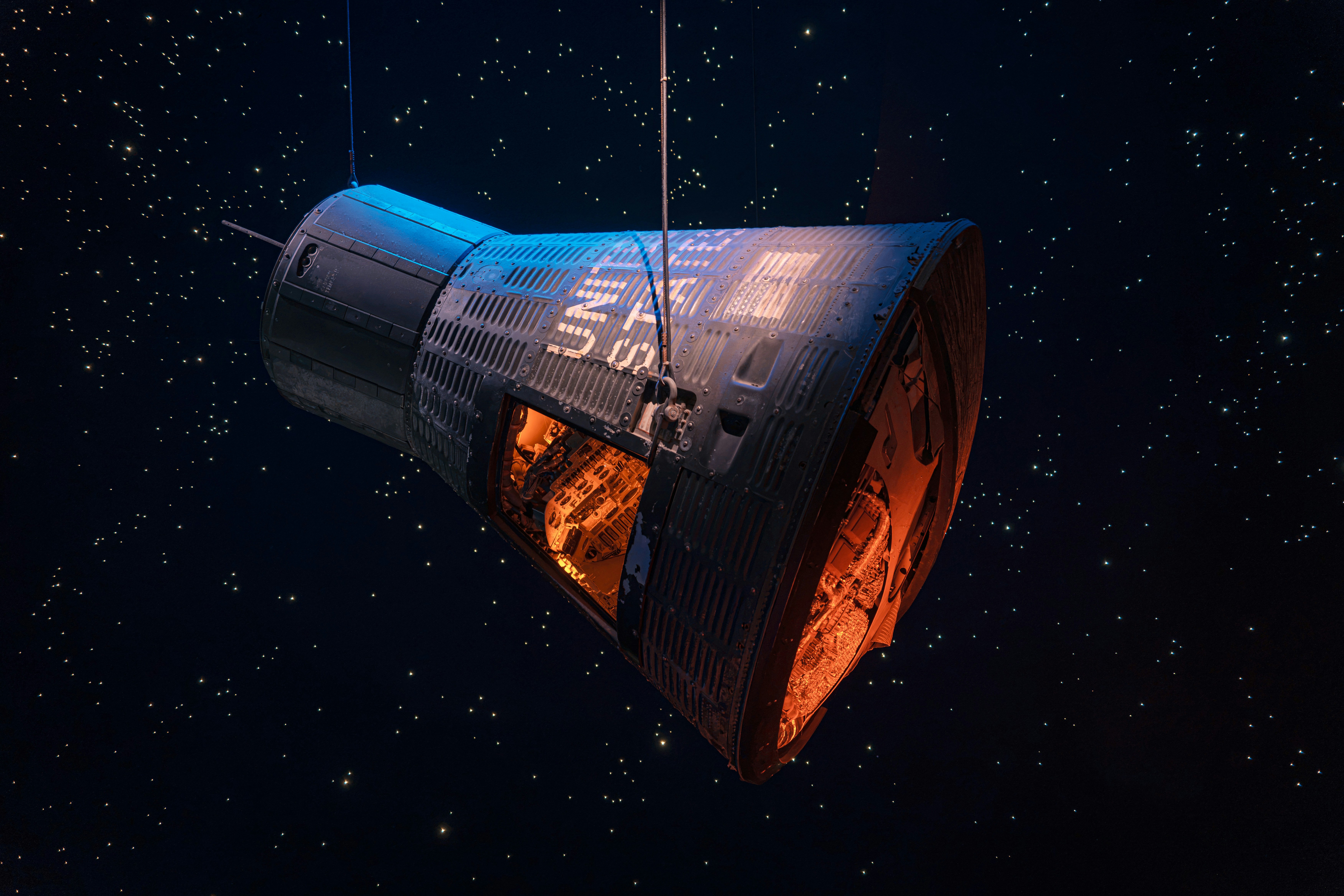 Una cápsula espacial suspendida sobre un fondo oscuro con puntos de luz dispersos