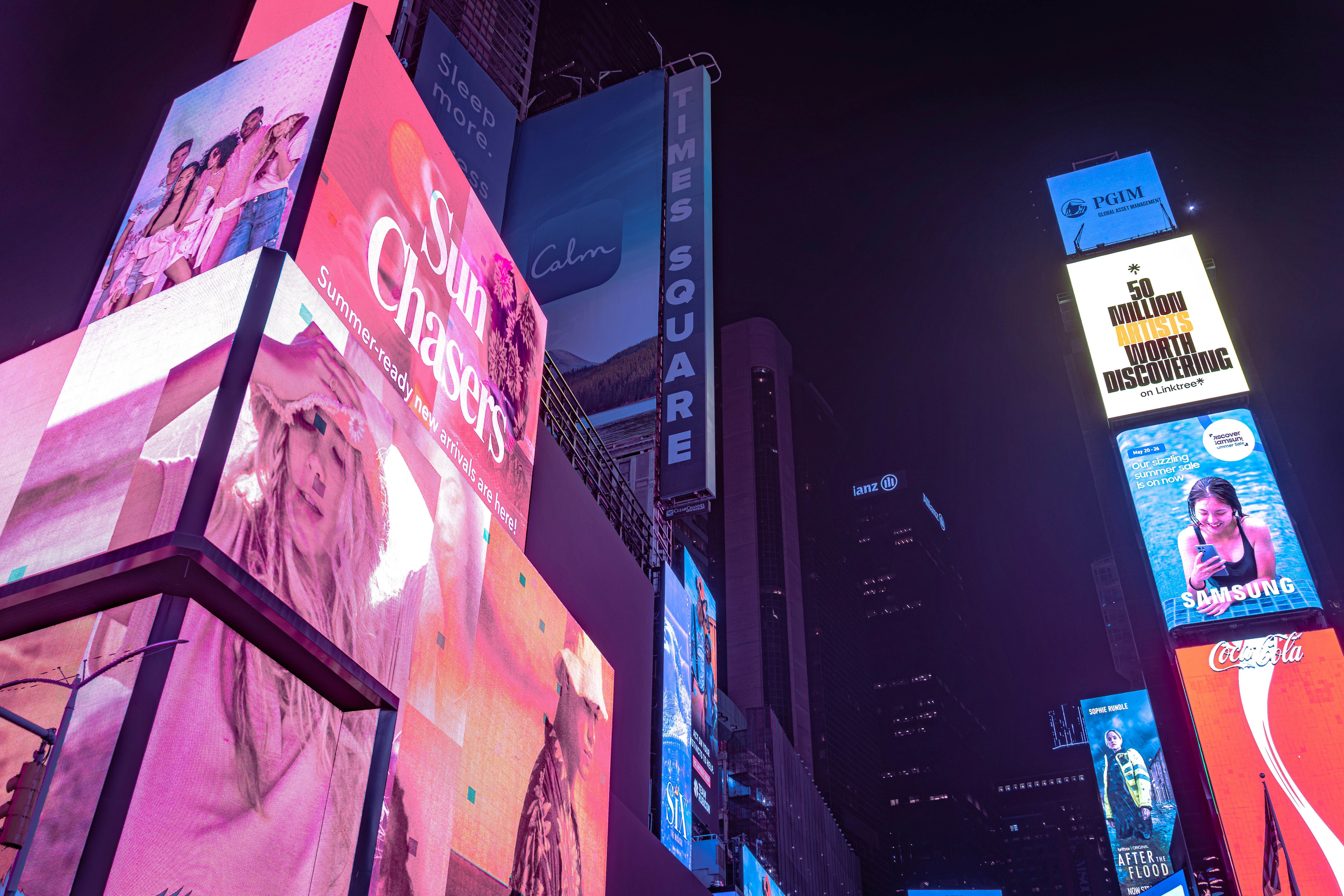Large illuminated digital billboards displaying advertisements in Times Square at night