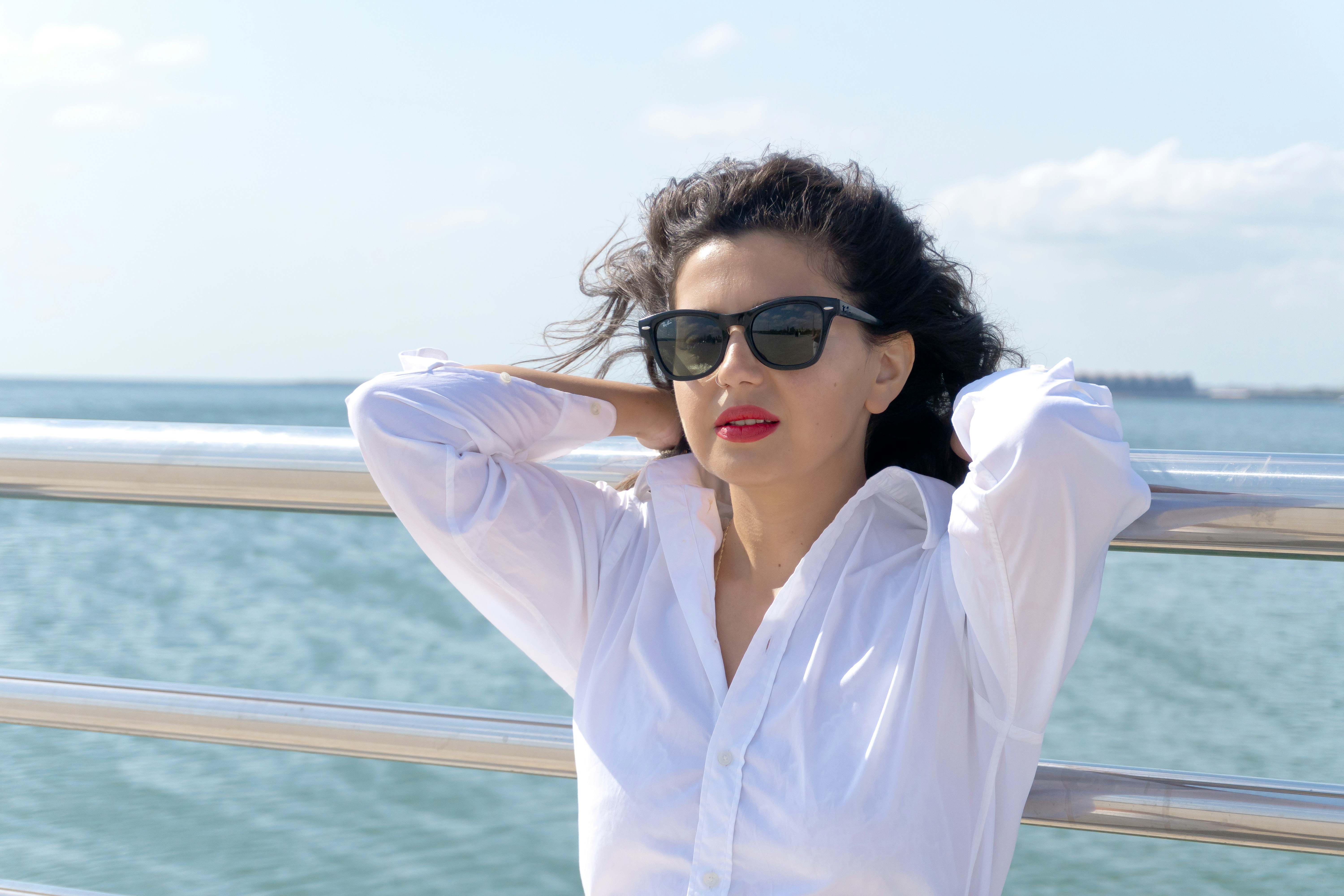 Linen shirt and sunglasses, hair caught by the wind