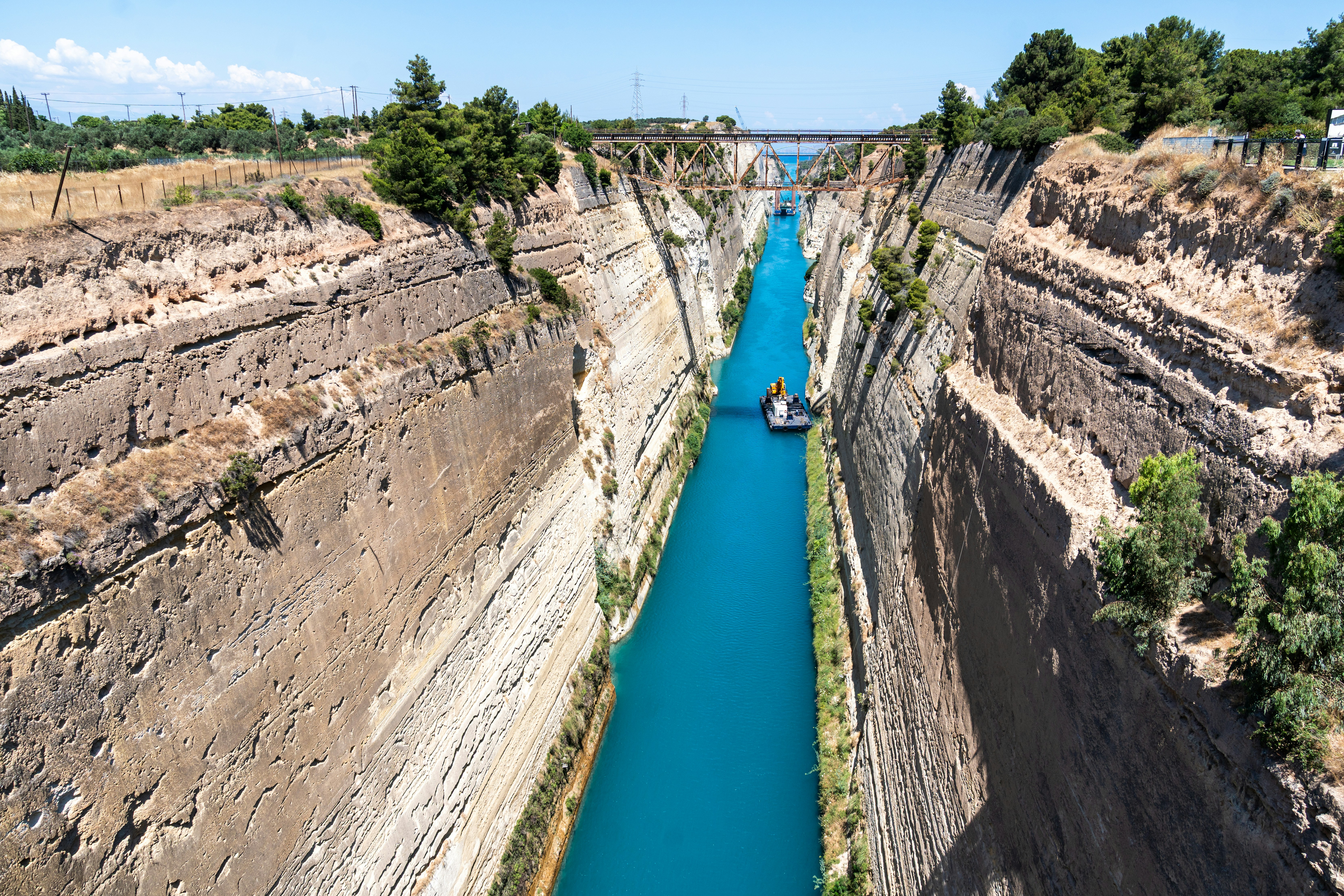 A small boat in the deep blue water of the Corinth Canal in Greece