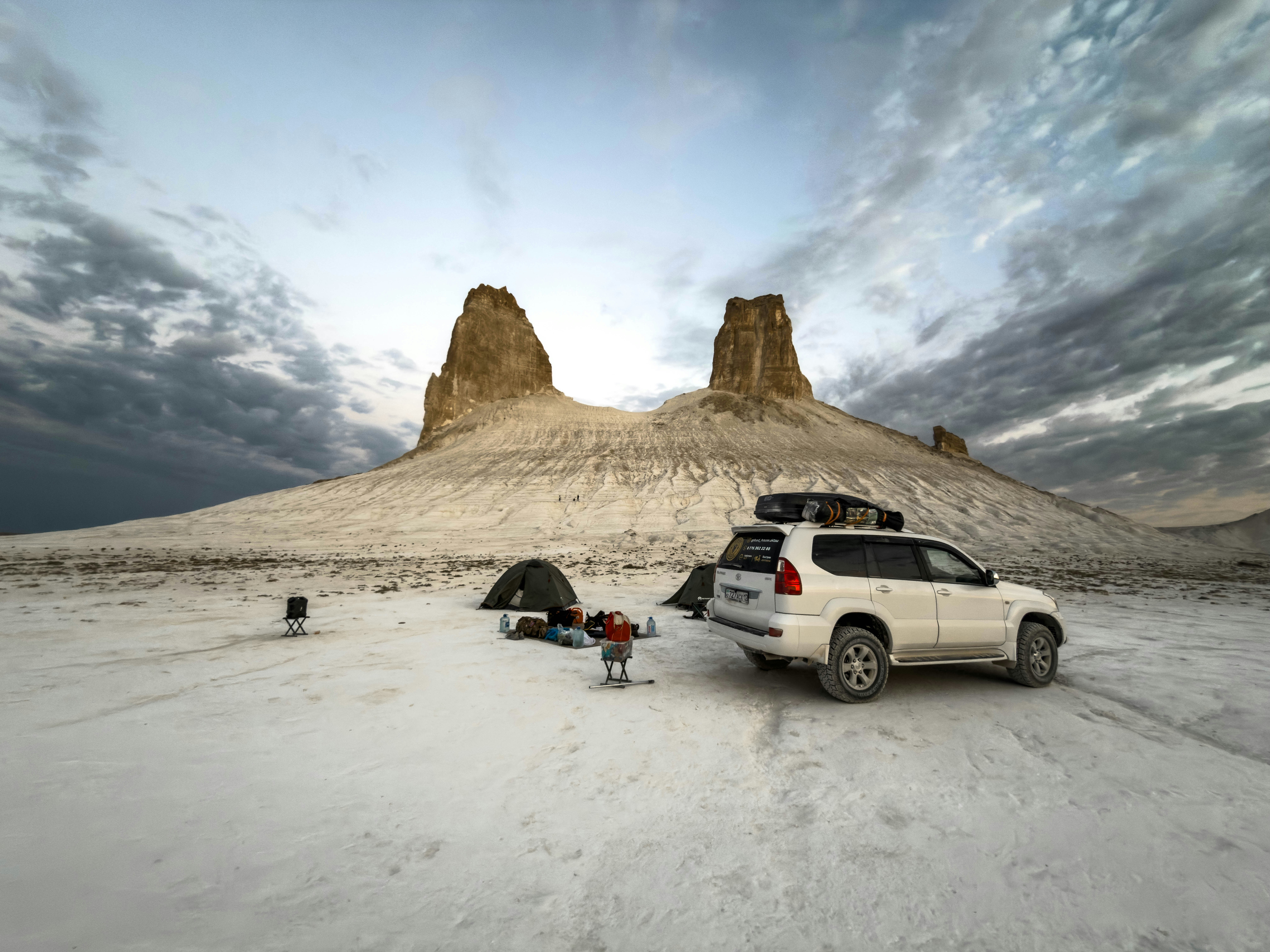 camper van parked in a desert campsite with solar panels on the roof