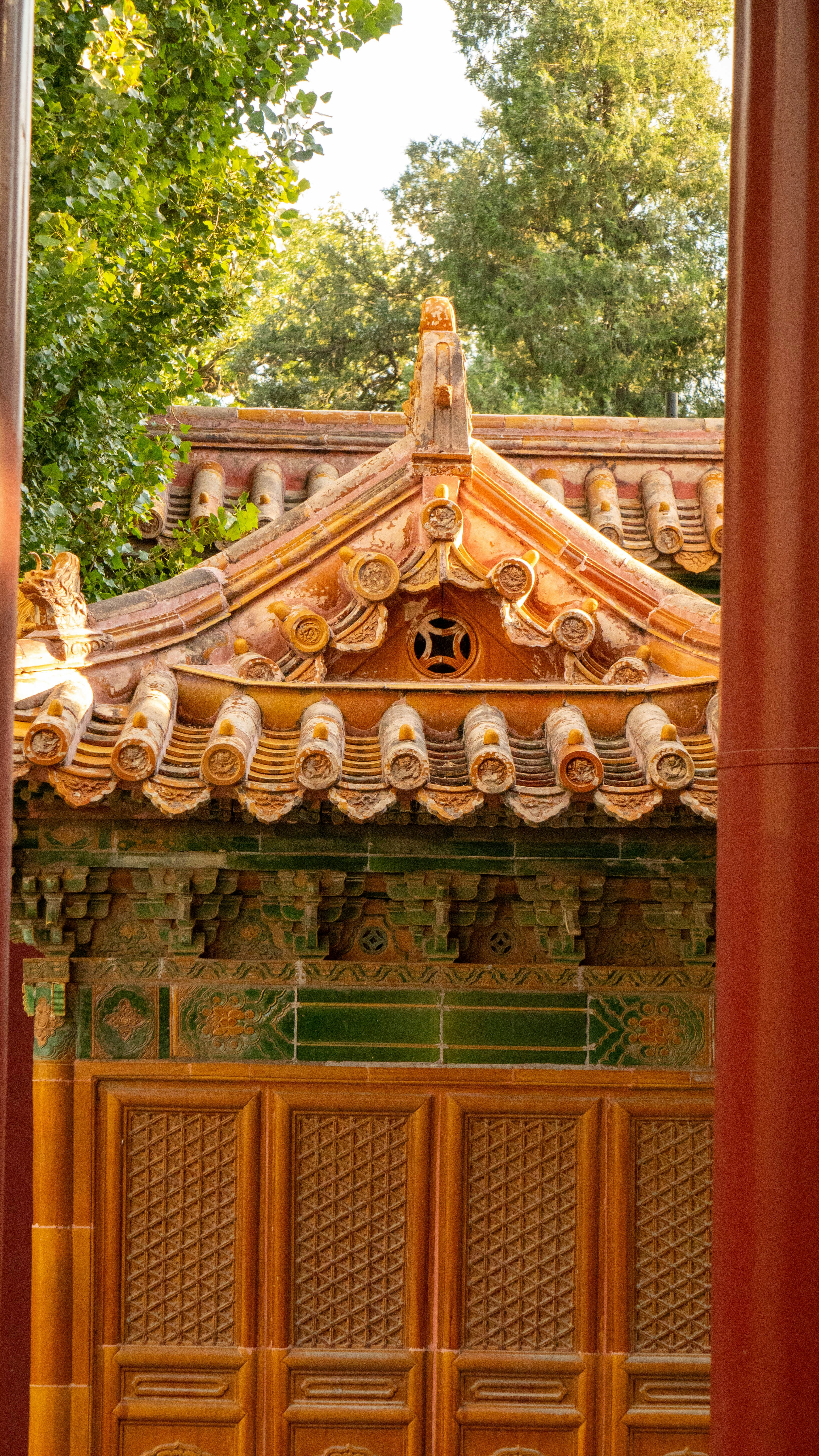 Ornate orange tiled roof of a traditional Chinese building with green decorative brackets