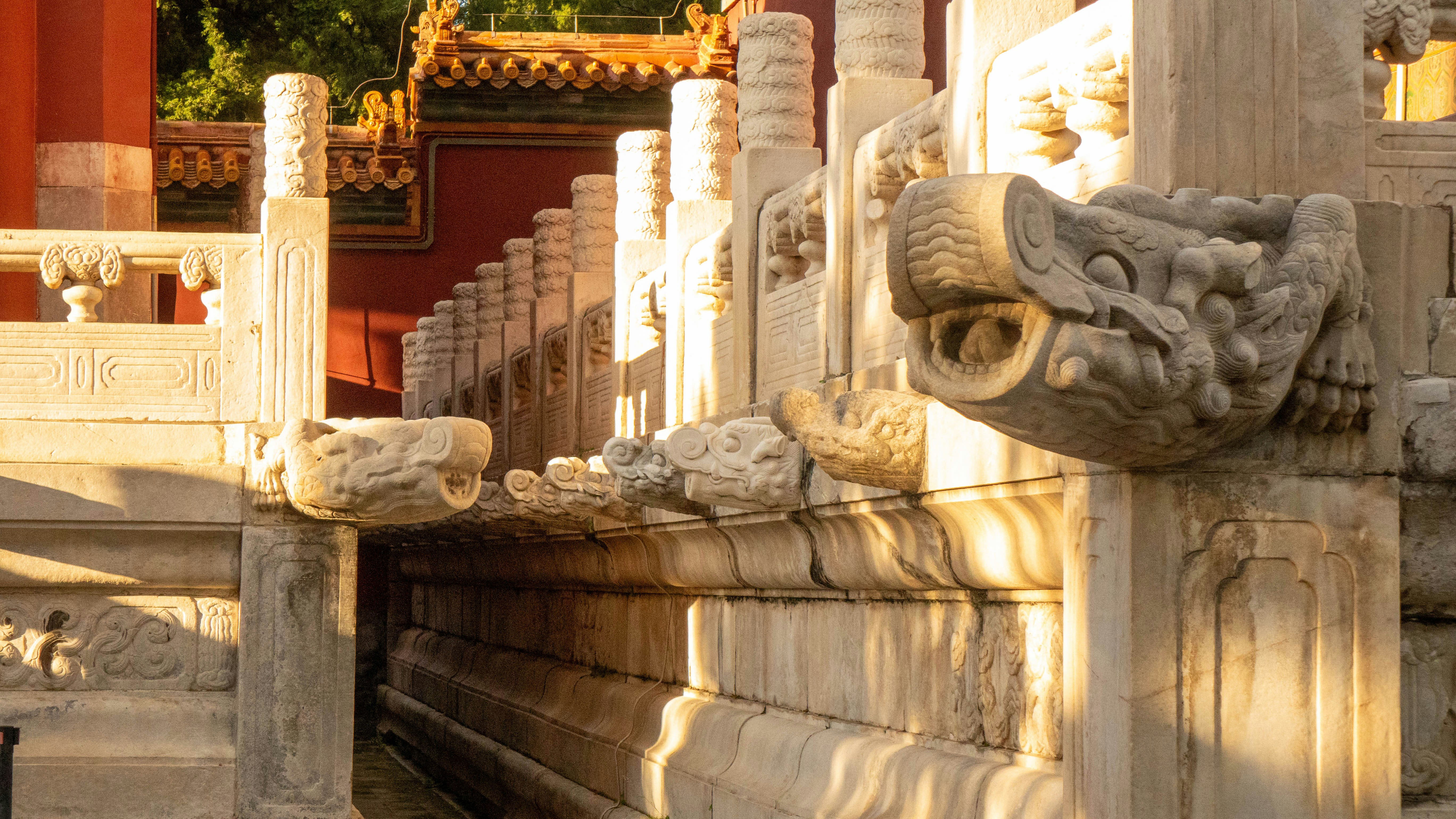 Carved stone dragon heads on a marble balustrade in the Forbidden City
