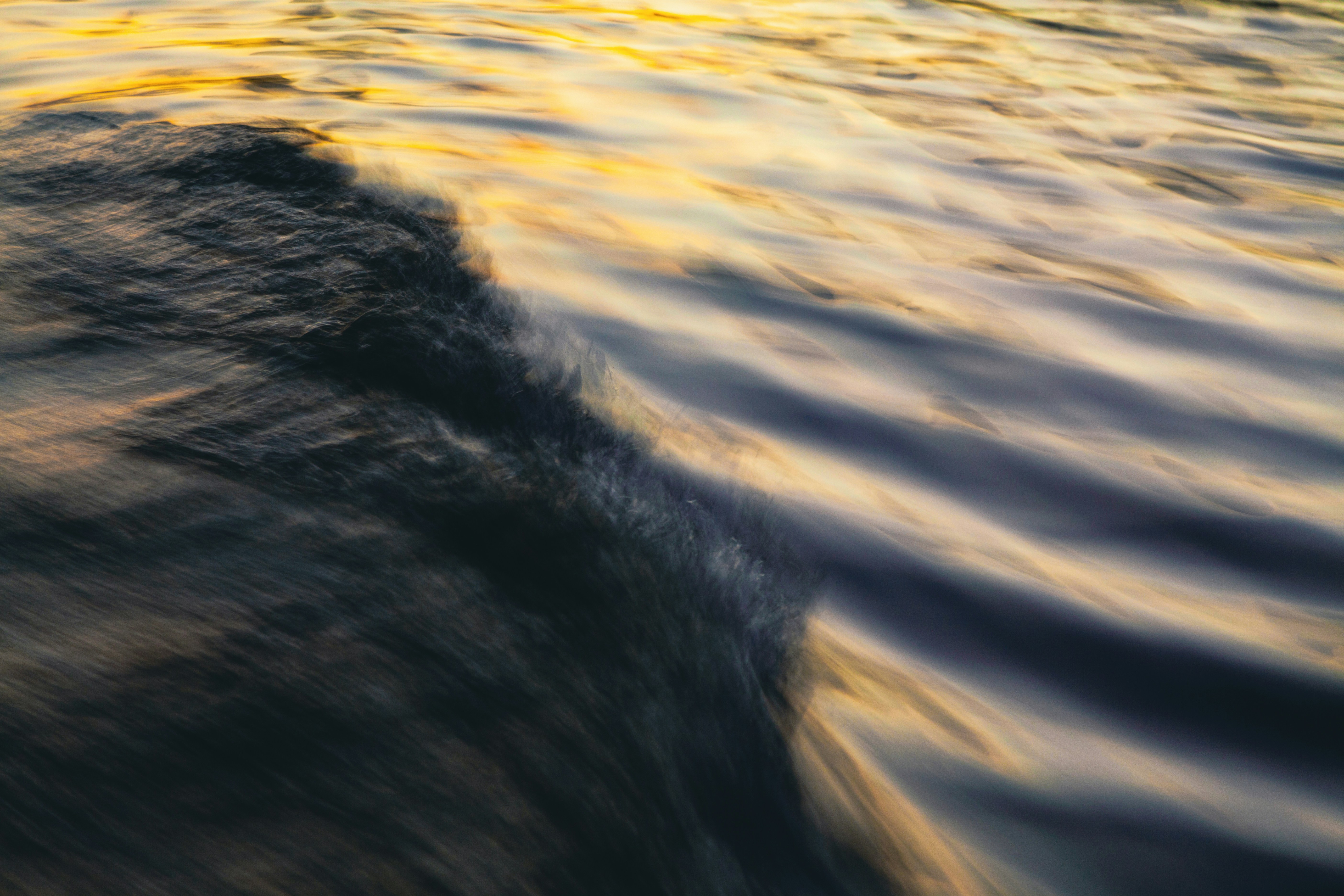Dark water ripples with golden light - Free Photo on Unsplash