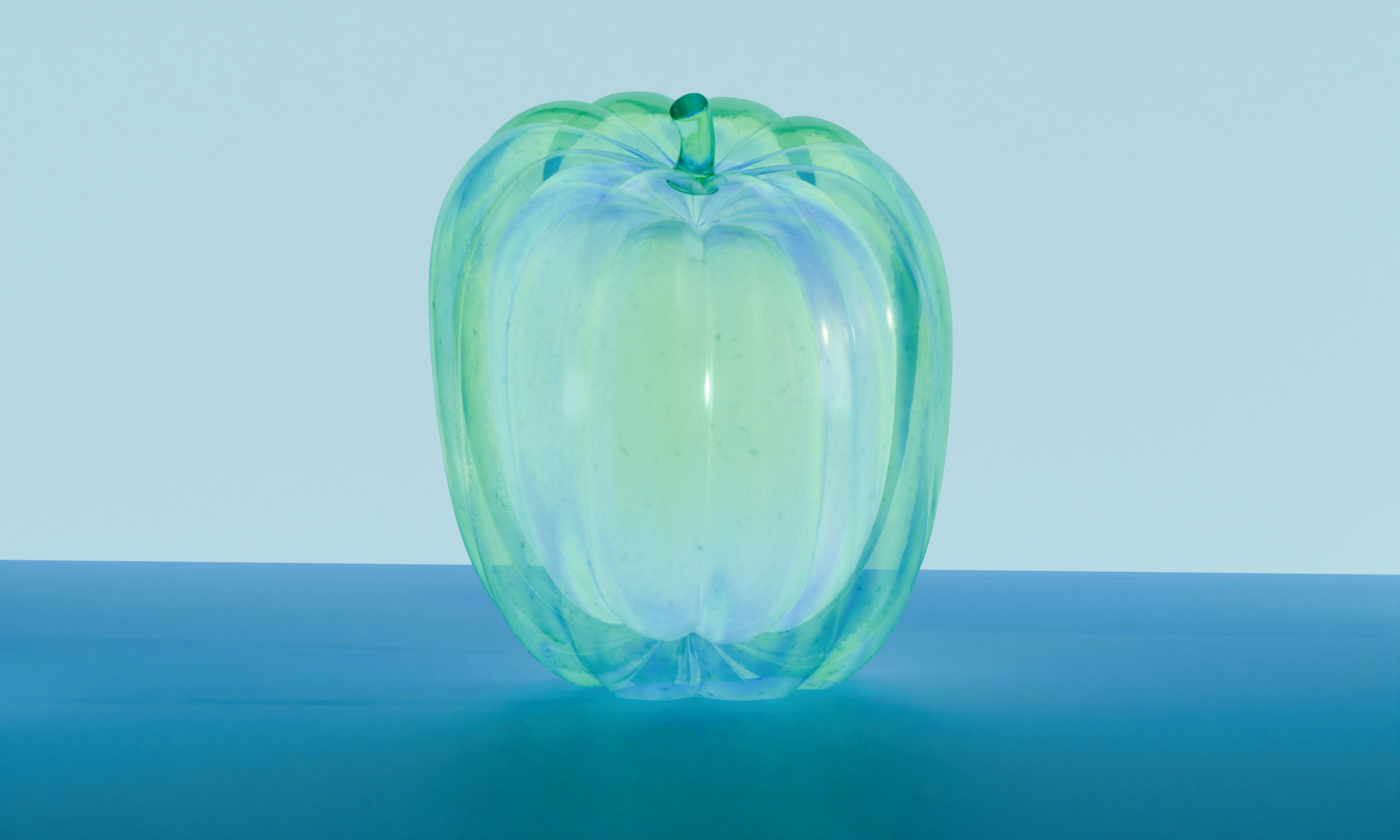 Ein durchscheinender grüner Glas-Kürbis auf einer blauen Oberfläche vor hellblauem Hintergrund